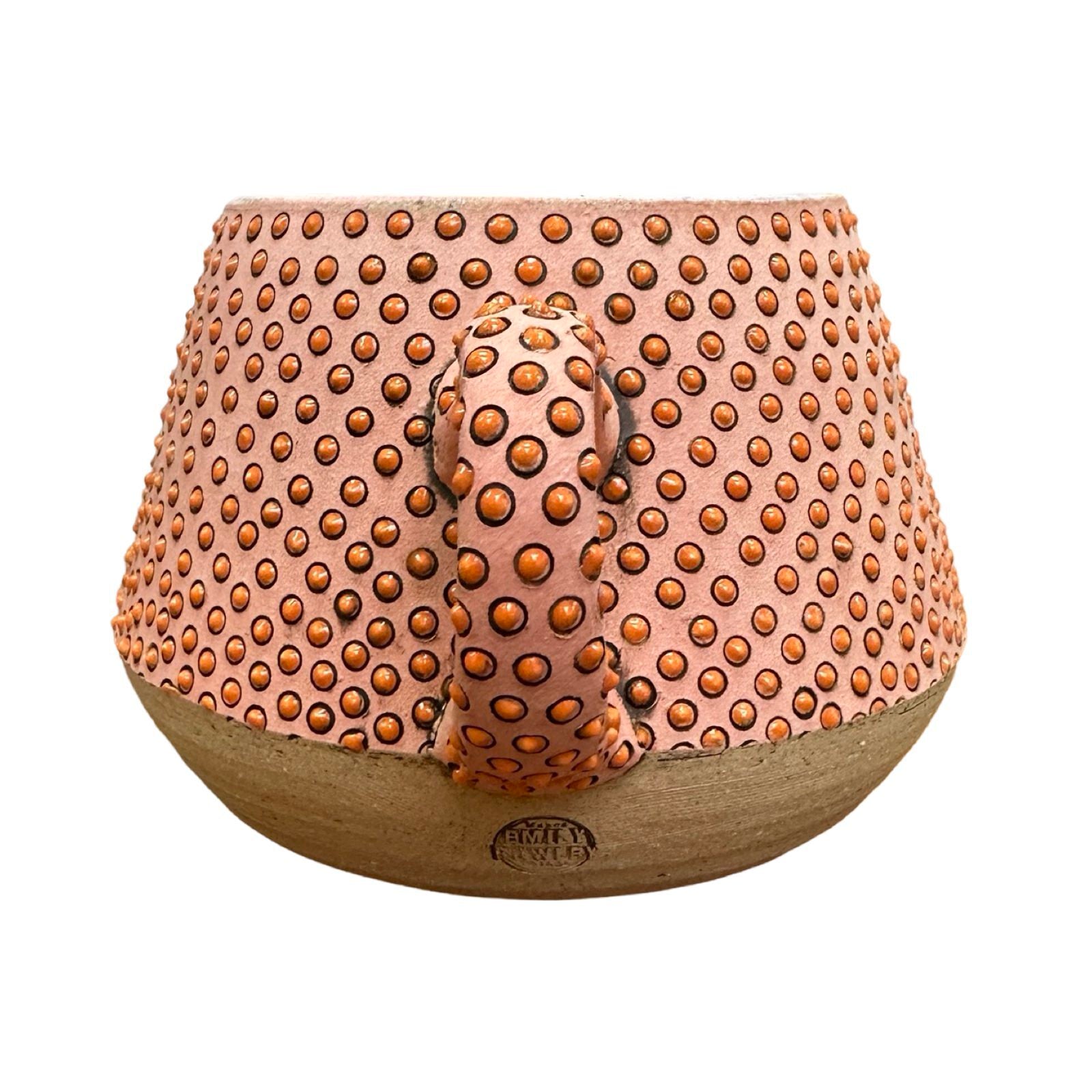 A handmade ceramic mug with a carved man's face and moustache, glazed in pink with a red diamond design.