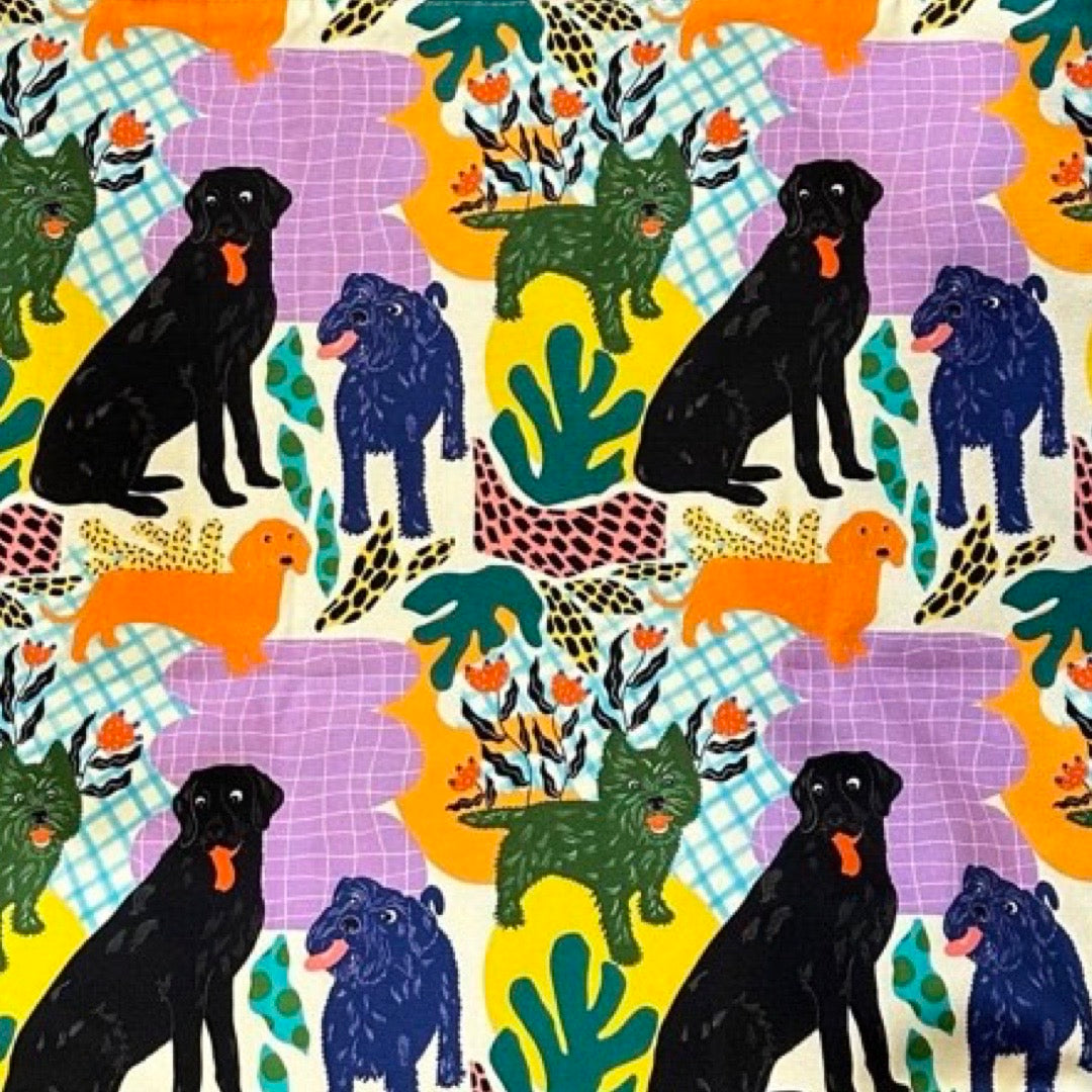 Patterned fabric with black dogs, colorful plants, and checkered backgrounds.