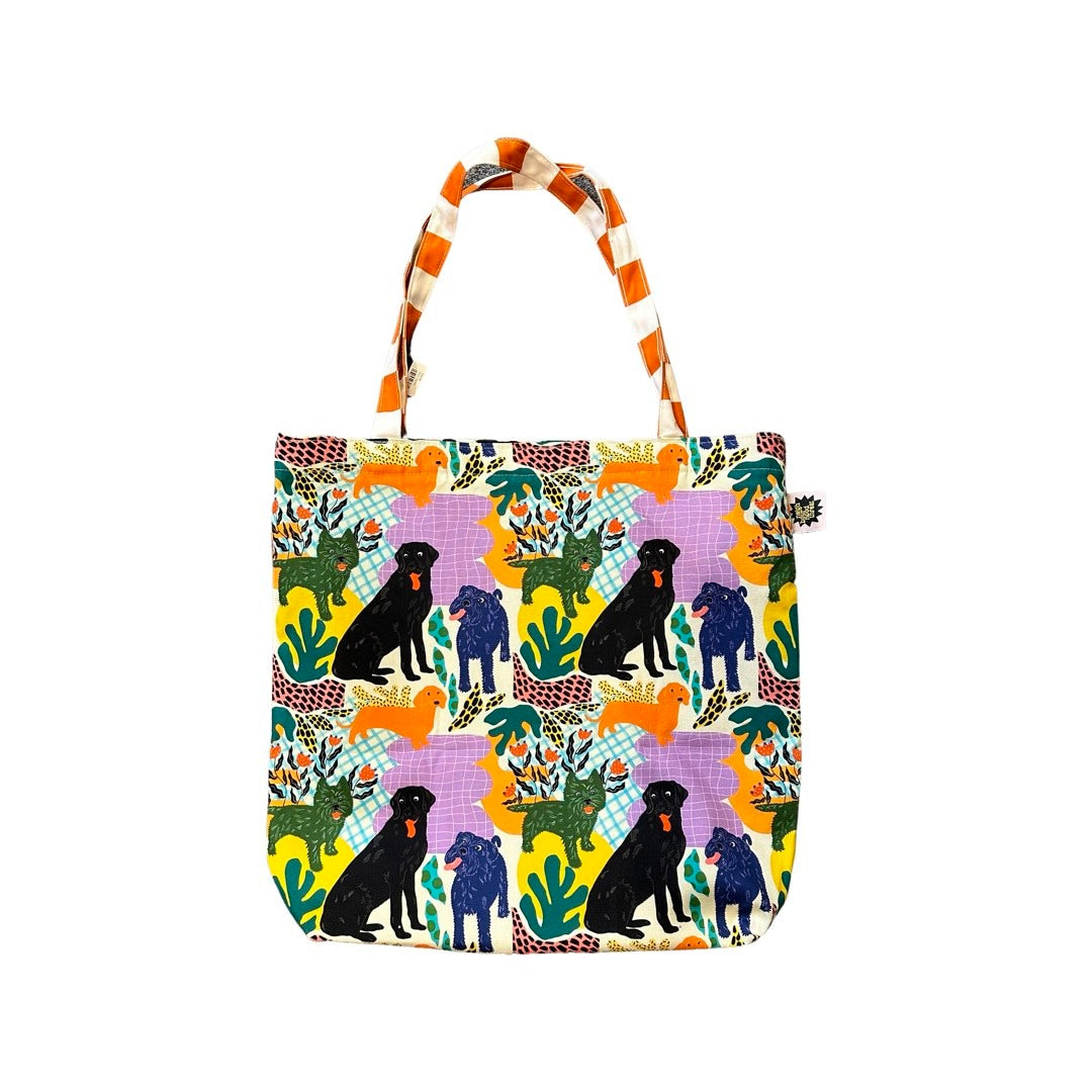 Fabulous tote bag featuring black labradors, orange dachshunds and green scottie dogs with green leaves and a lilac background with orange and white checked cotton handles.