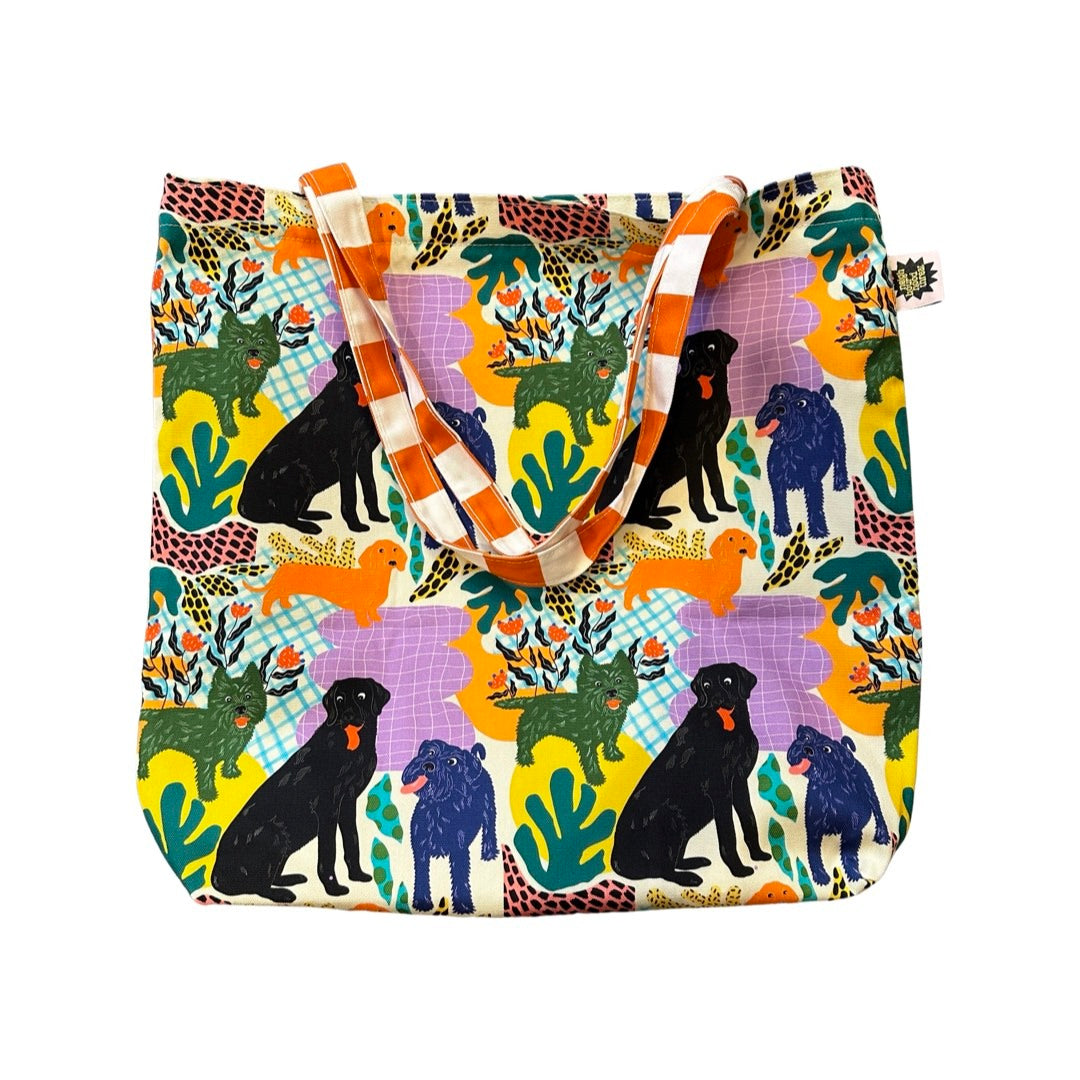 Fabulous tote bag featuring black labradors, orange dachshunds and green scottie dogs with green leaves and a lilac background with orange and white checked cotton handles.