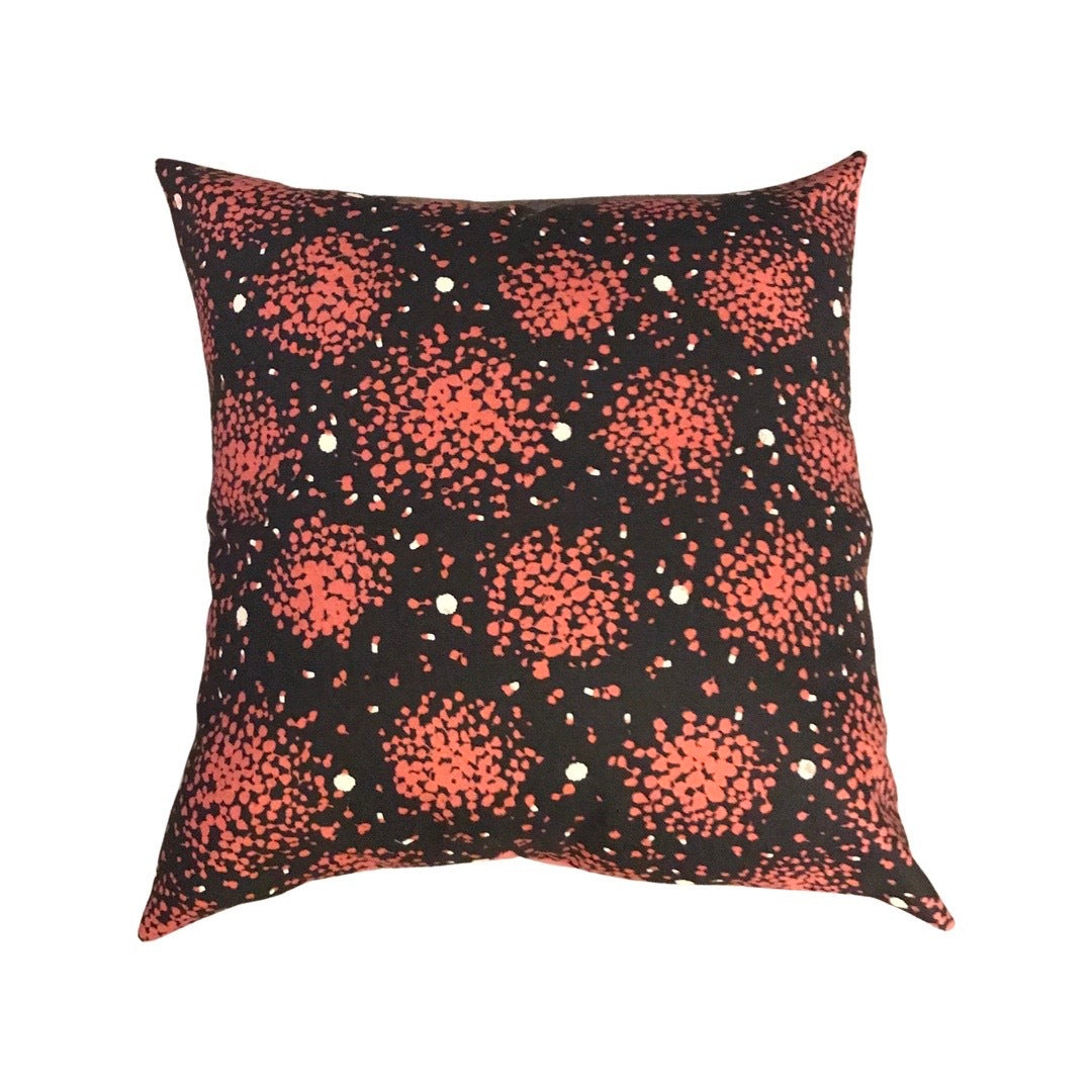 A square cushion cover with a charcoal background featuring irregular pops of pink pattern.
