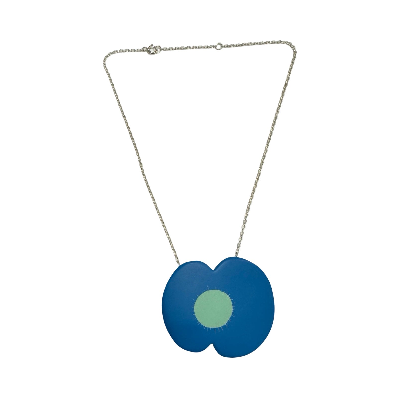 A blue resin poppy-shaped necklace with a pale green centre on a silver chain.