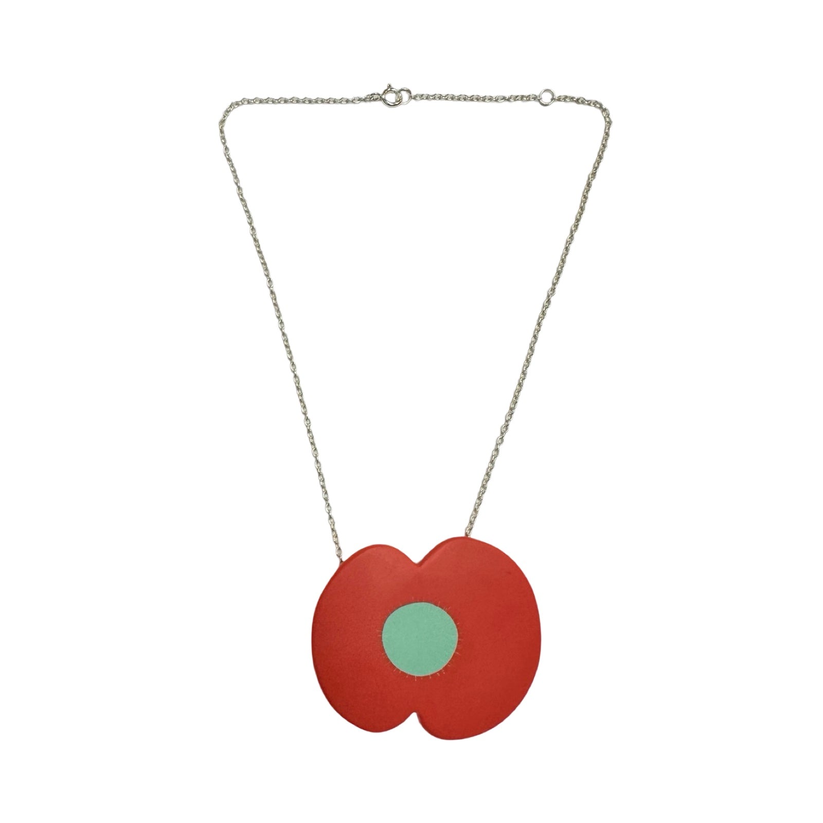 A red resin poppy-shaped necklace with a green centre on a silver chain.