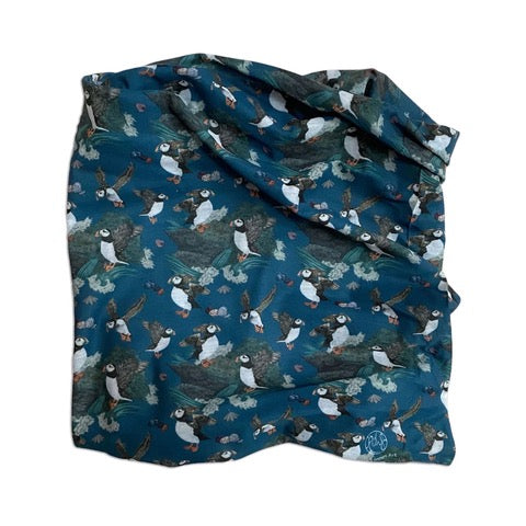A neck warmer featuring illustrations of flying puffins. 