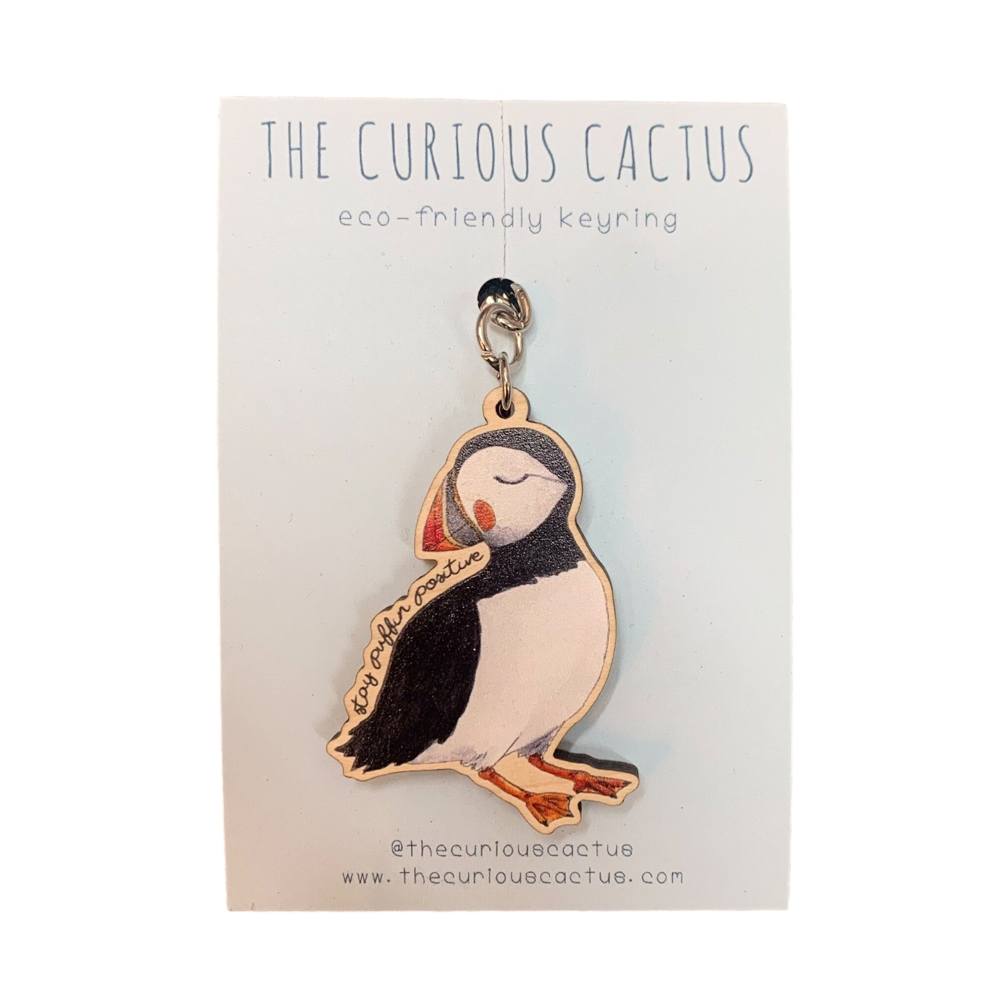 A wooden keying of a puffin on a light blue backing card.