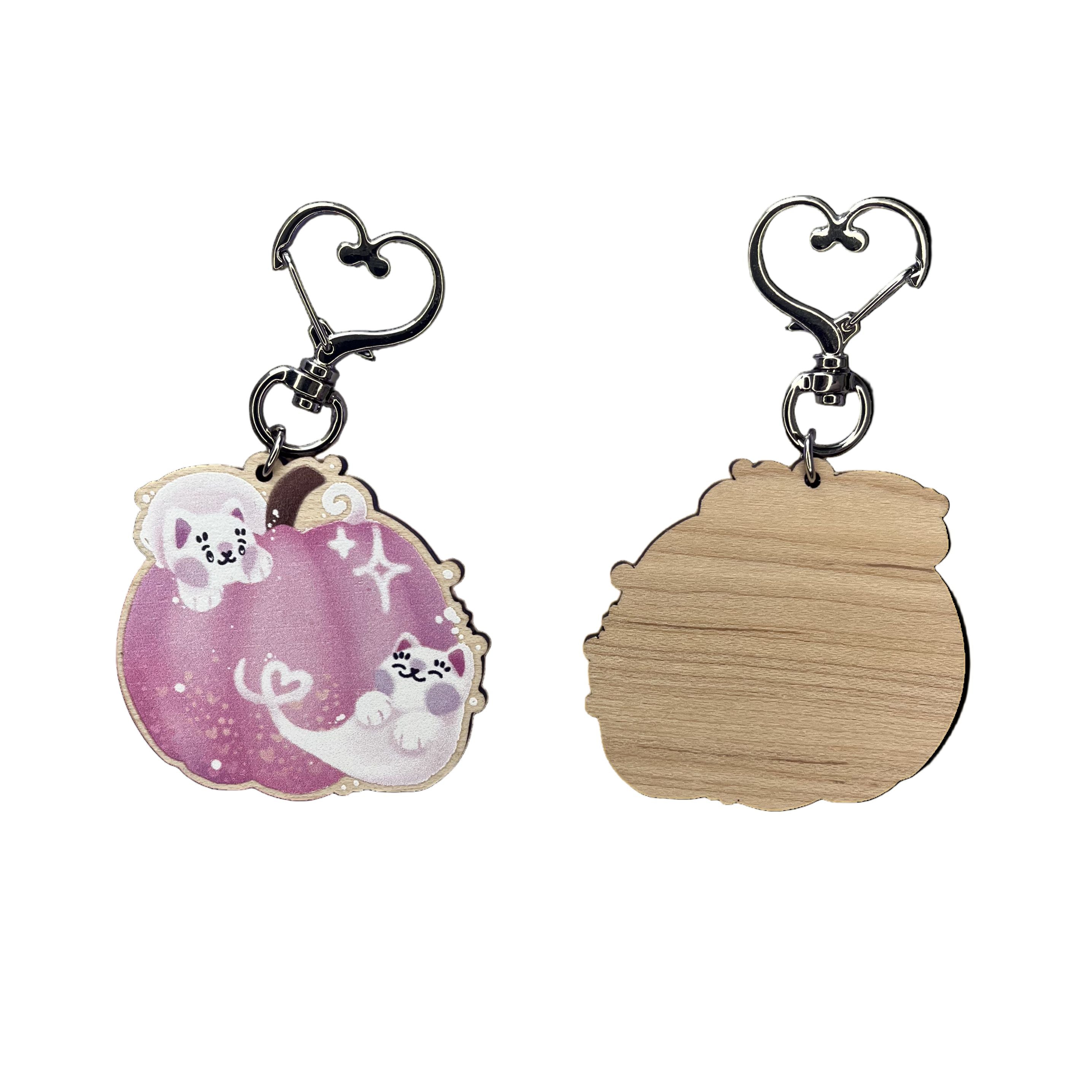 Front (left) and back (right) of a pink pumpkin jack-o-lantern keyring with two cat ghosts in this keyring design. 