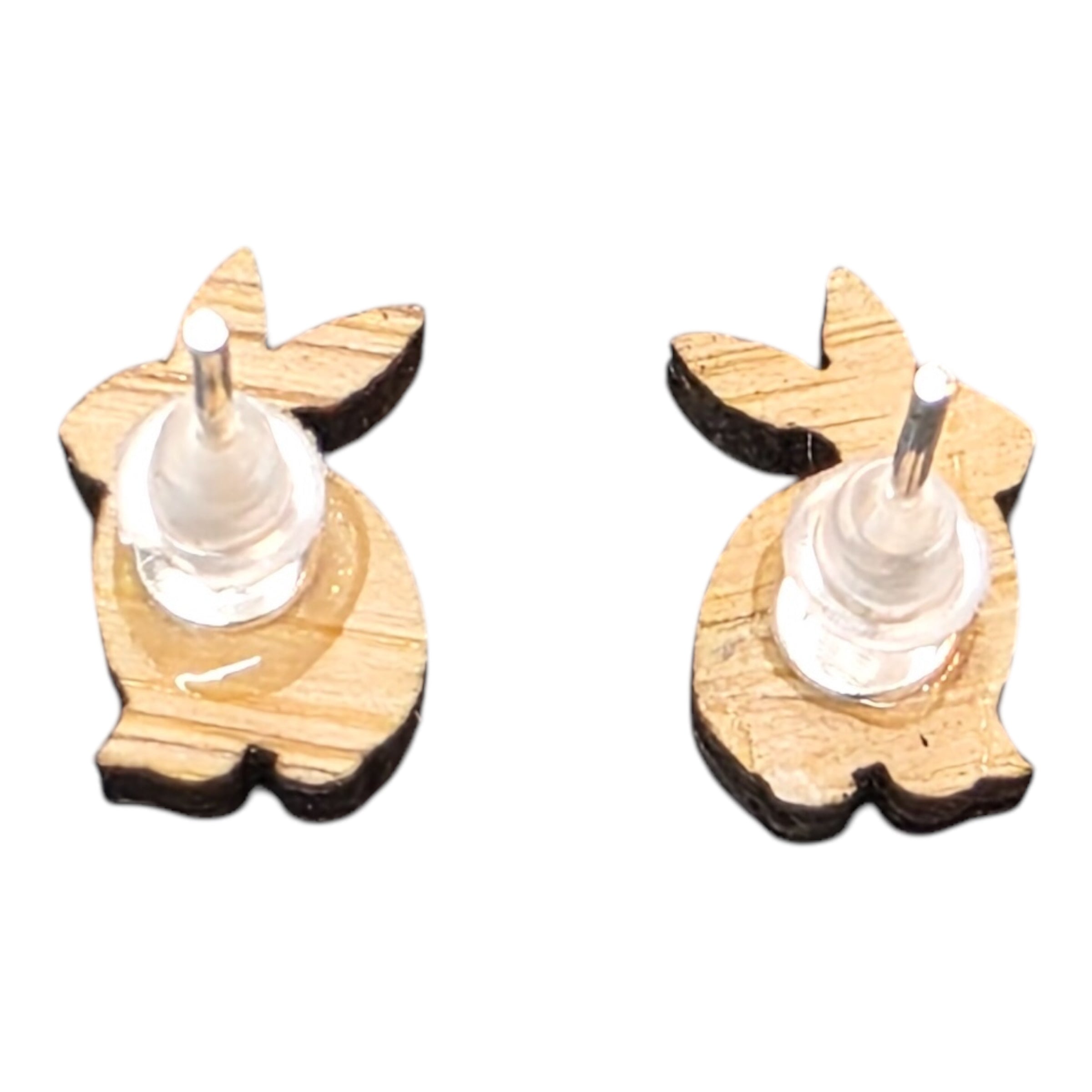 The back of a pair of rabbit-shaped wooden earrings with silver coloured posts and rubber backs.