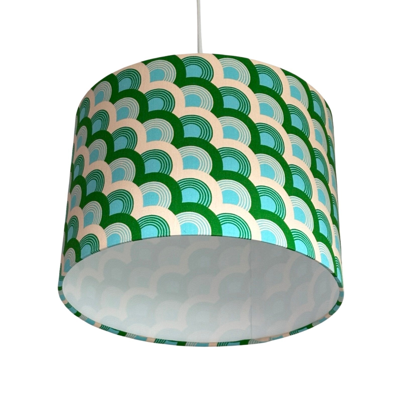 Close up of a drum lampshade with green, turquoise and white rainbows