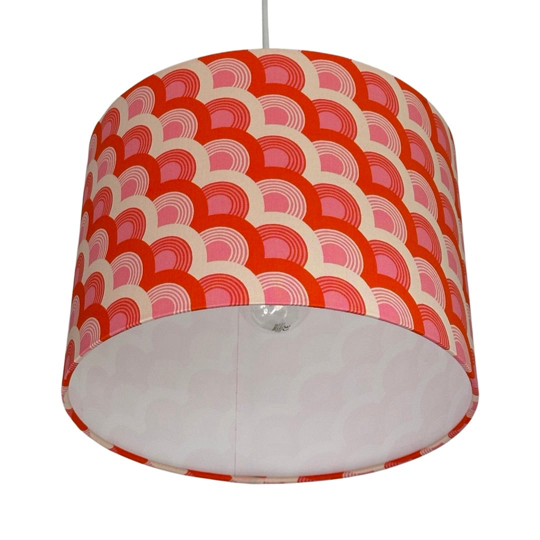 Close up of drum lampshade covered in red, pink and white rainbows