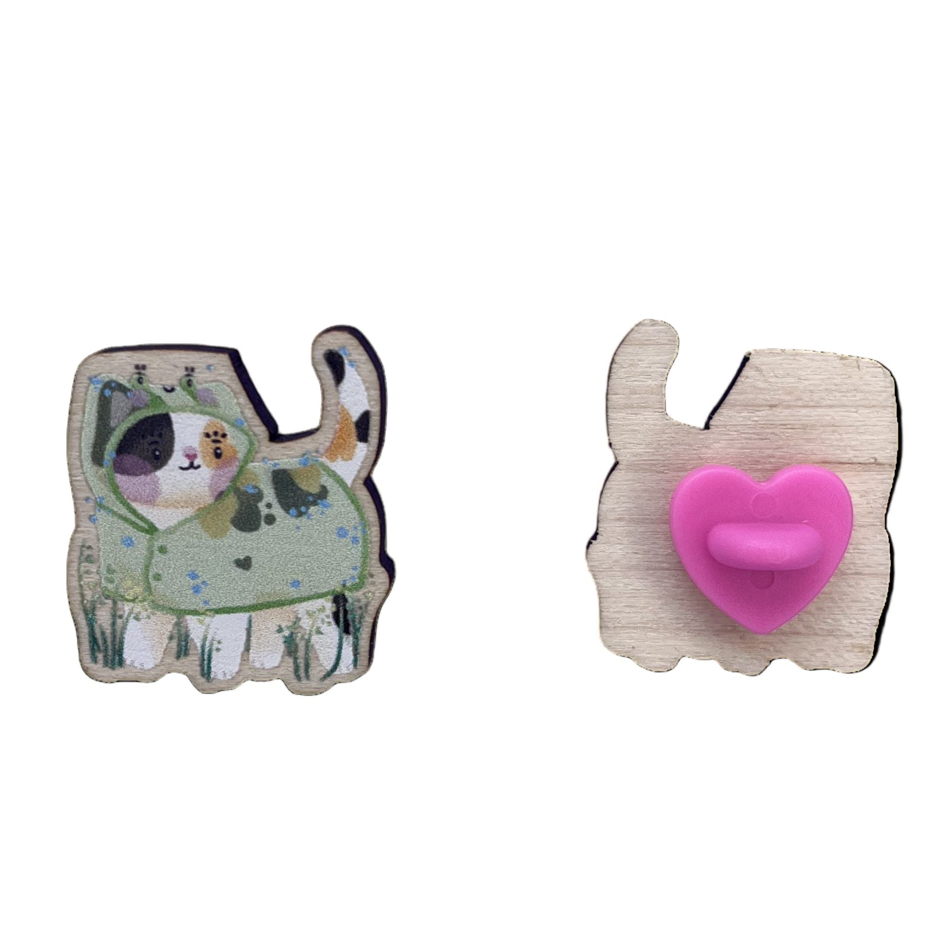 Wooden pin badge of a calico cat wearing a frog raincoat (left) and it's back (right)