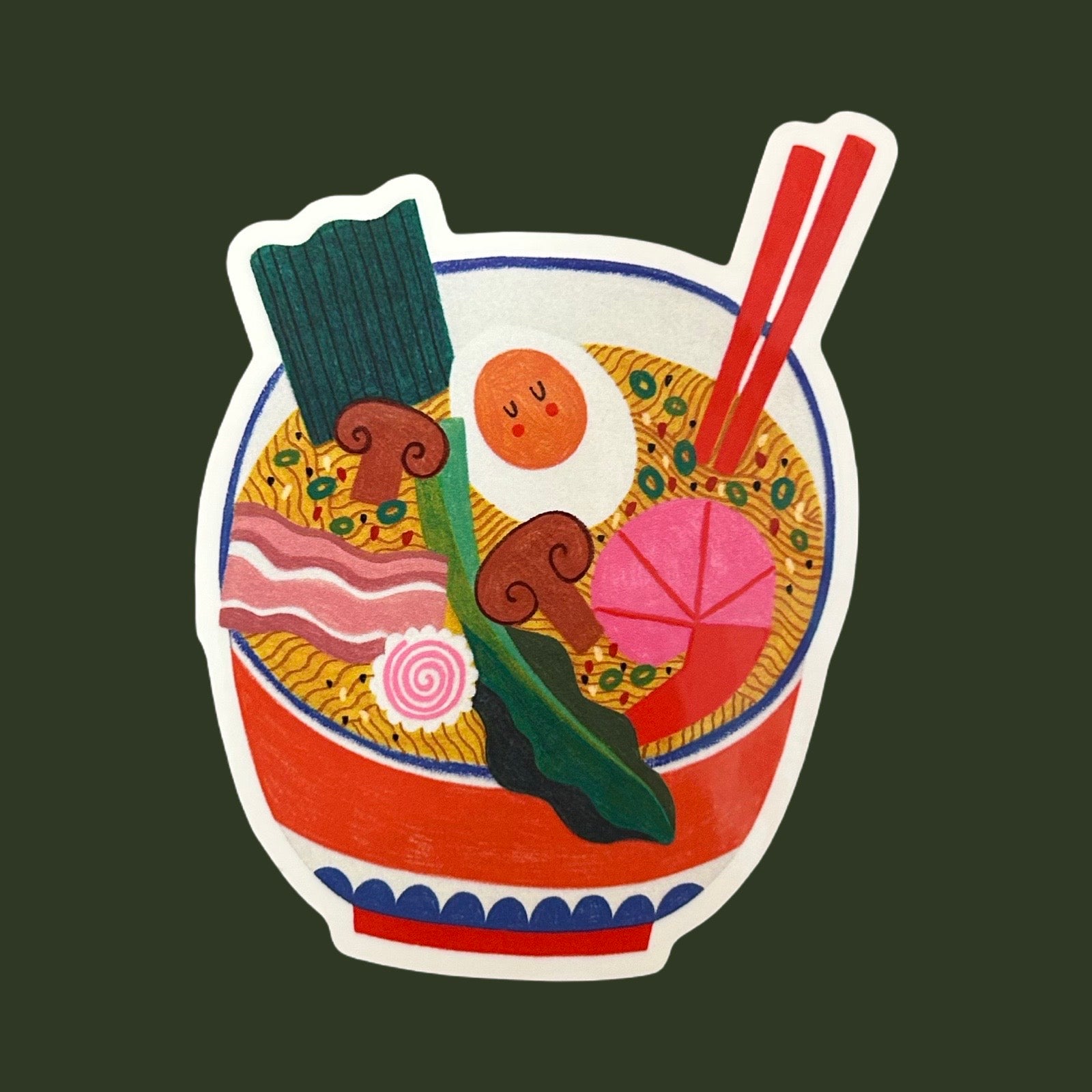 A sticker featuring a whimsical, hand-drawn illustration of a ramen bowl with a smiling egg, chopsticks, mushrooms, green onions, and prawns, set against a solid dark green background.