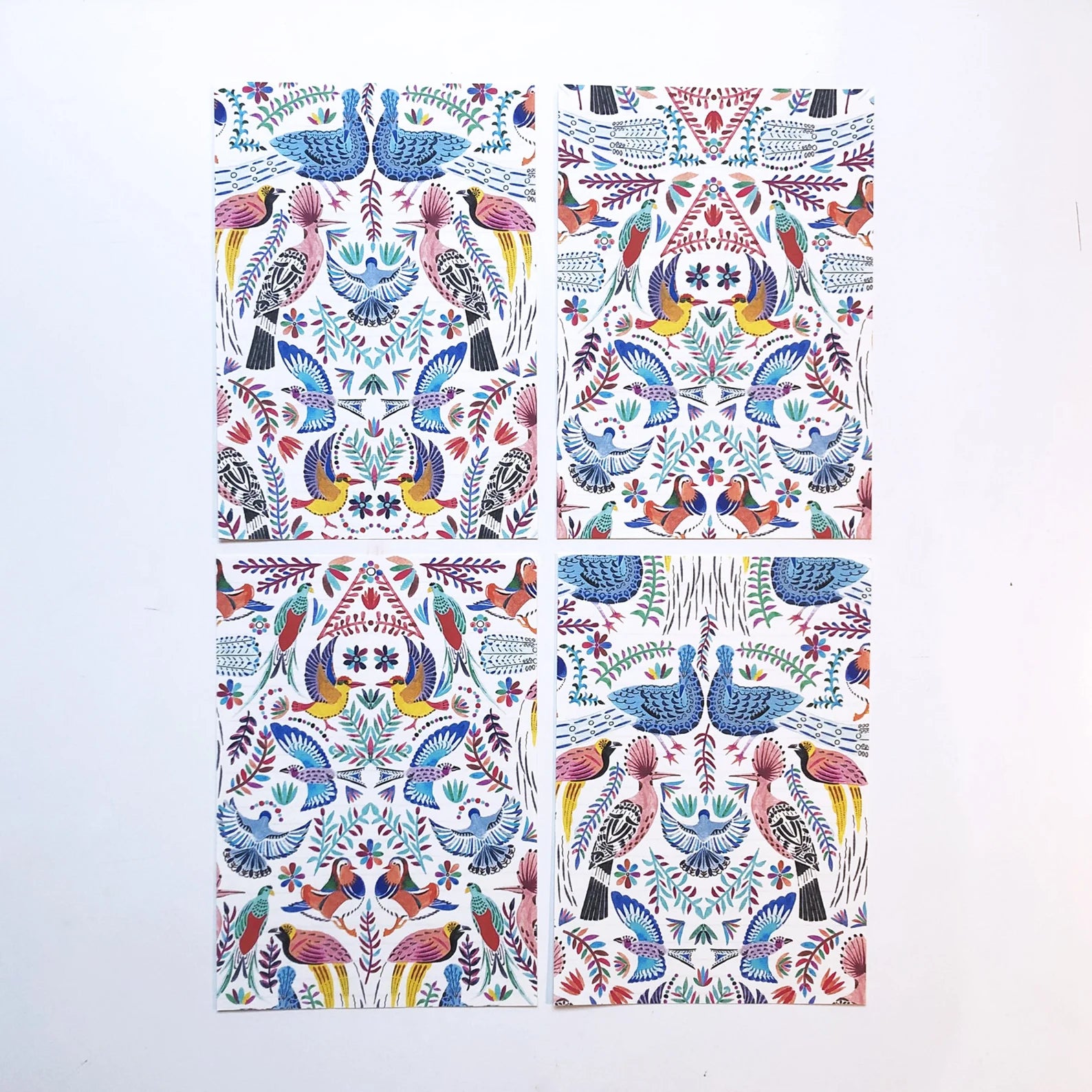 Four colorful patterned towels with bird designs on a white background.