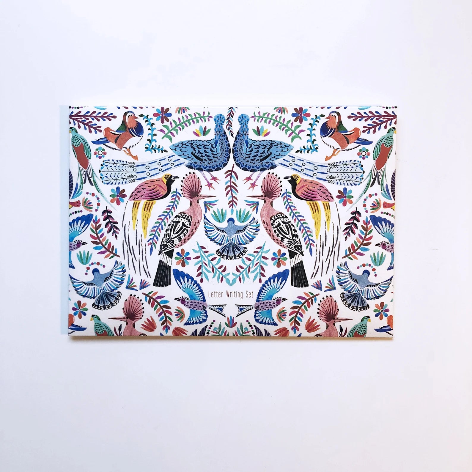 Colorful patterned paper with birds and floral designs on a white background.