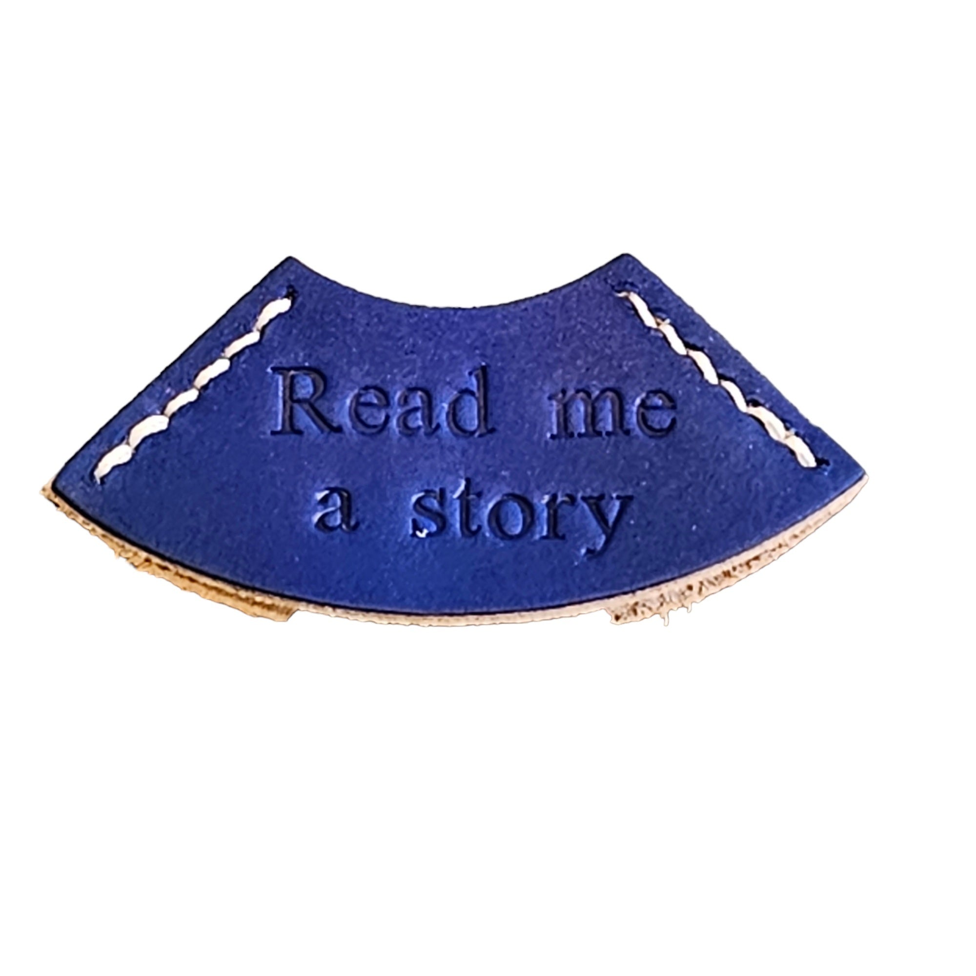 A blue leather bookmark with the embossed text 'READ ME A STORY'.