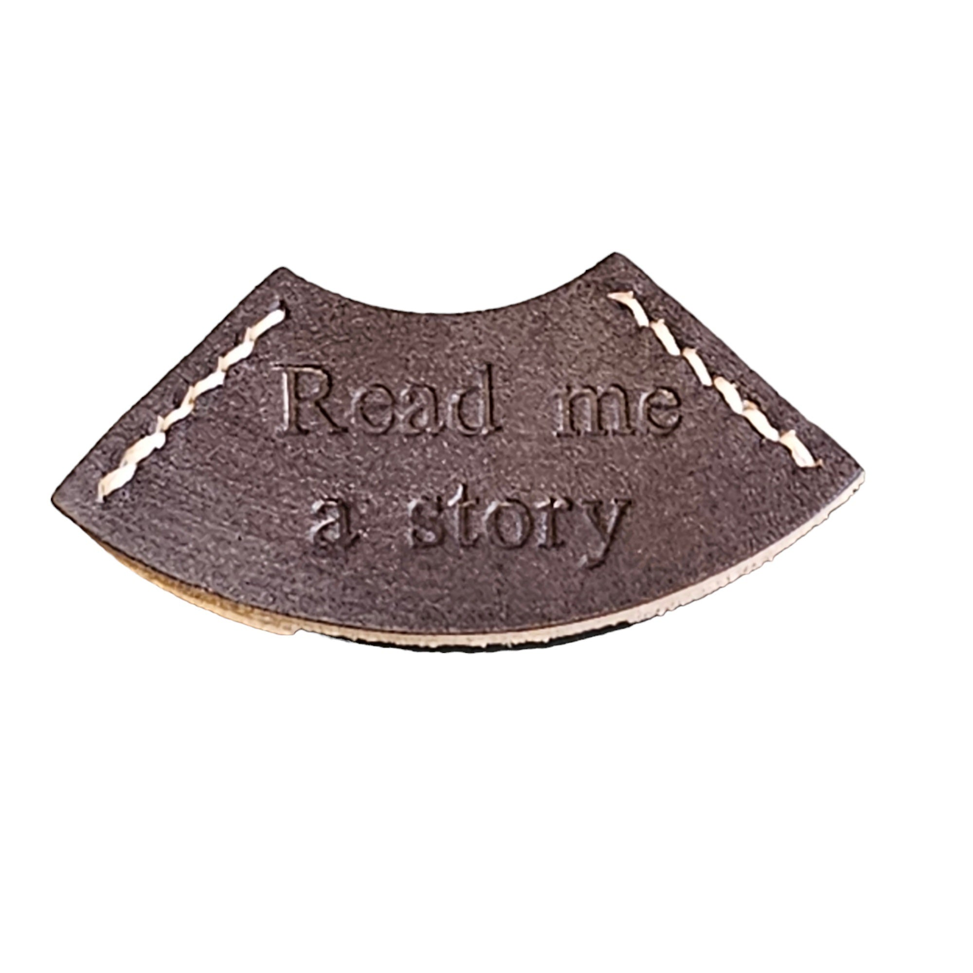 A gray leather bookmark with the embossed text 'READ ME A STORY'.