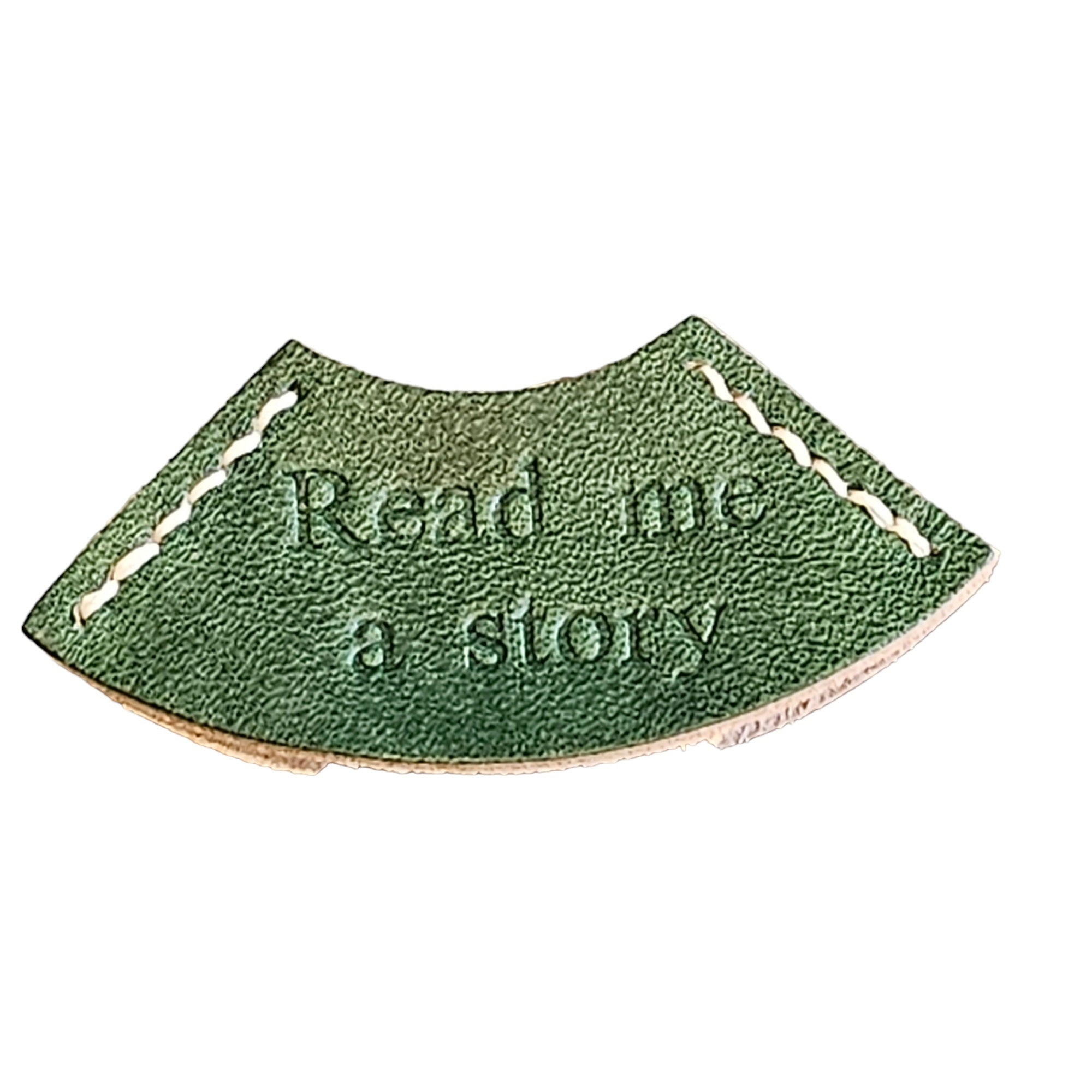 A green leather bookmark with the embossed text 'READ ME A STORY'.