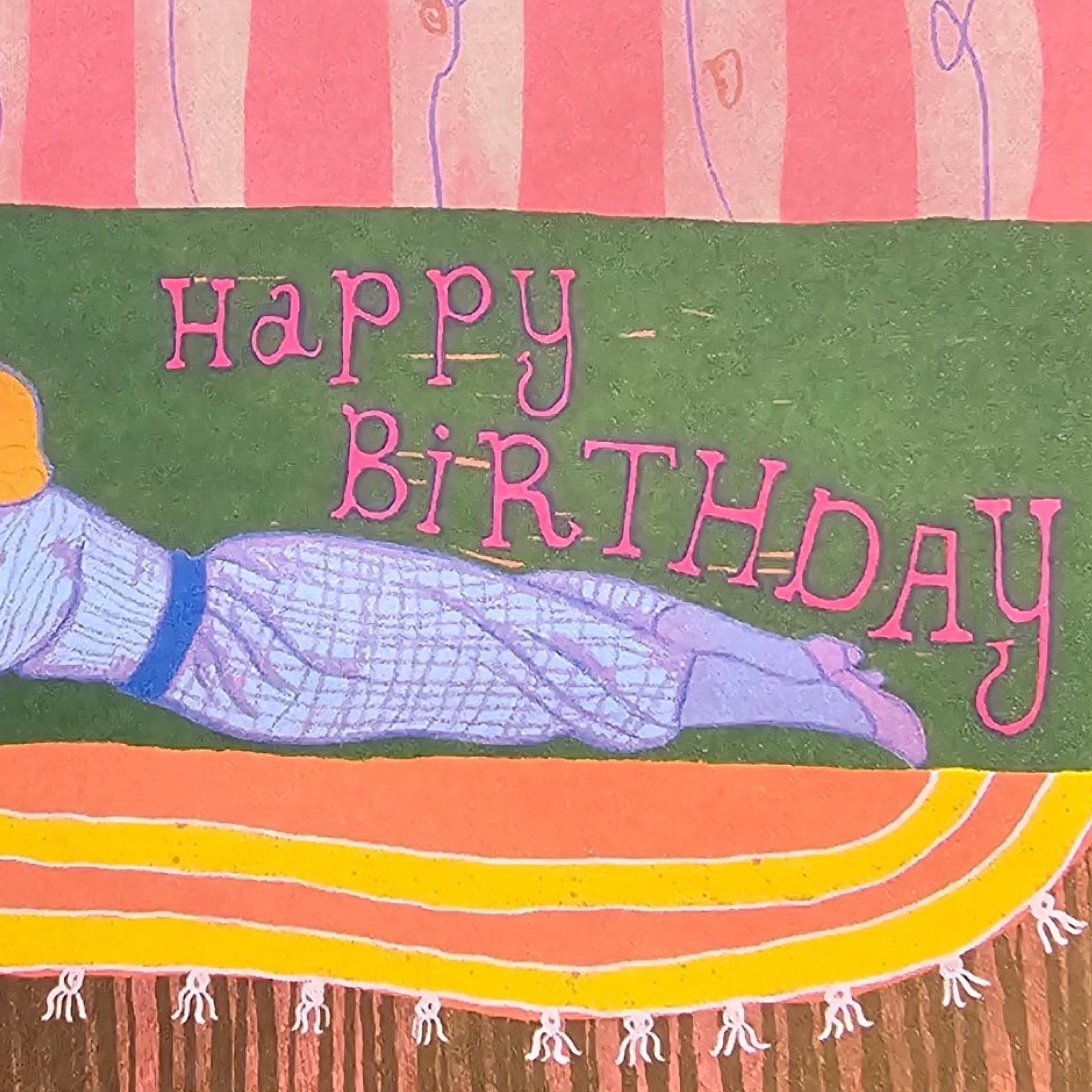 Colourful birthday card with a person lying on a towel and 'Happy Birthday' text.