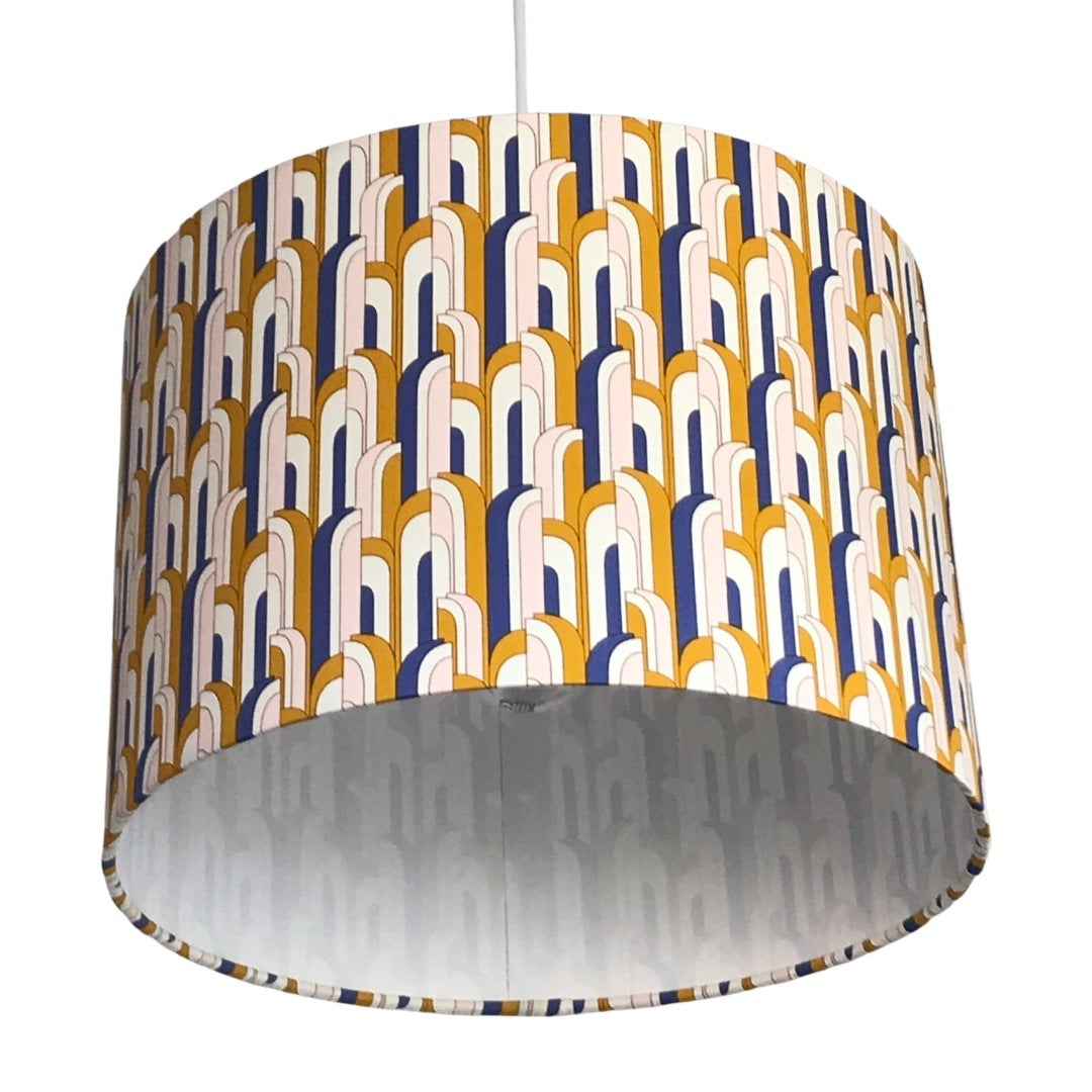 Close up of a drum lampshade in a blue, white and mustard mid-century-inspired retro arch design