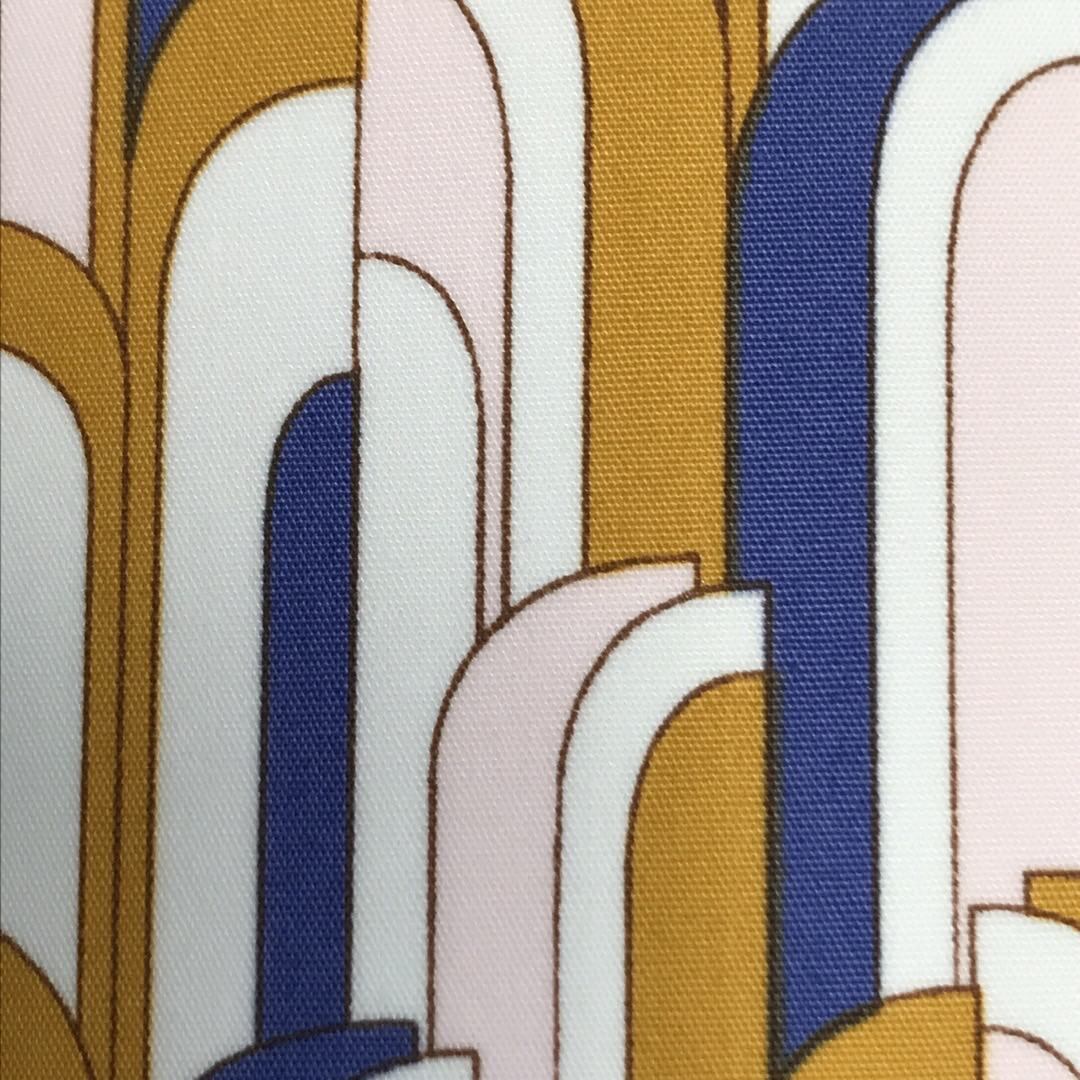 Cotton fabric in a blue, white and mustard mid-century-inspired retro arch design