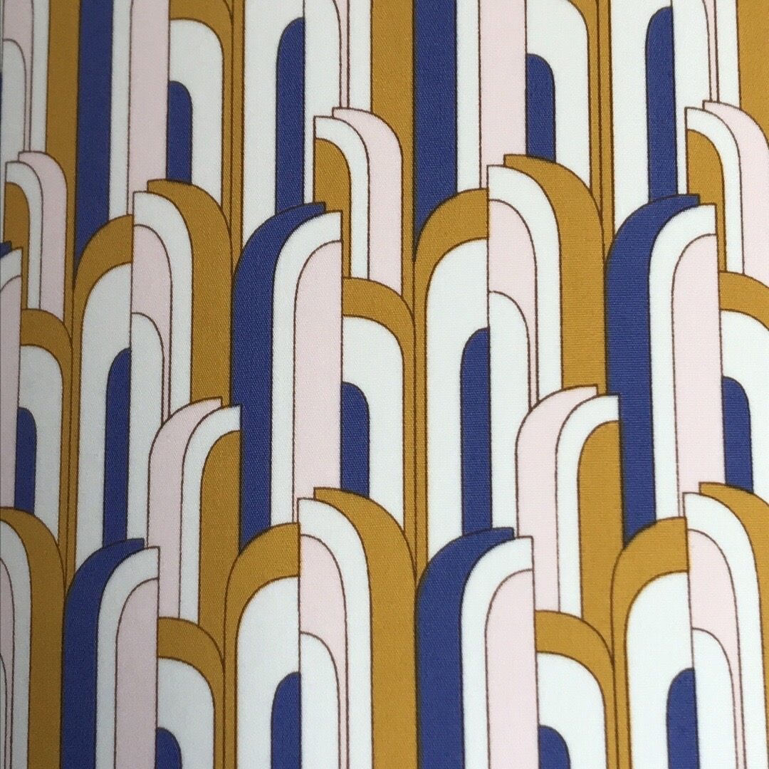 Cotton fabric in a blue, white and mustard mid-century-inspired retro arch design