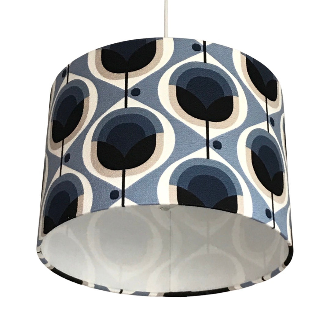Drum lampshade covered in mid-century inspired floral barkcloth fabric in blue, black, white and grey