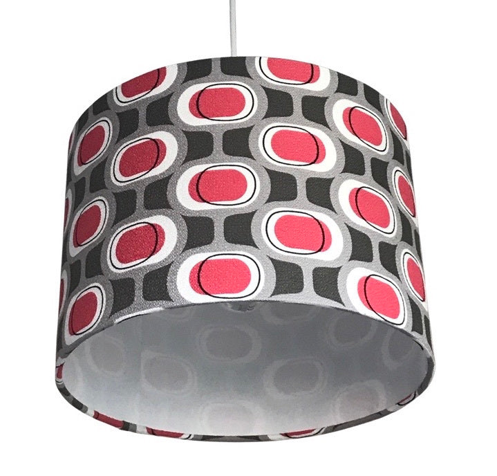 Drum lampshade covered in barkcloth fabric with a mid-century red and grey pattern