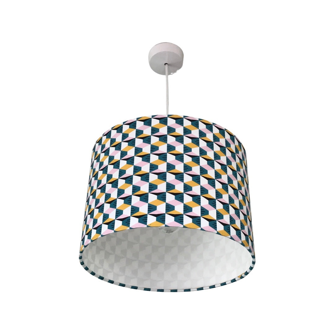 Drum lampshade covered in retro-style cotton fabric with a mustard, pink, white and blue geometric pattern.