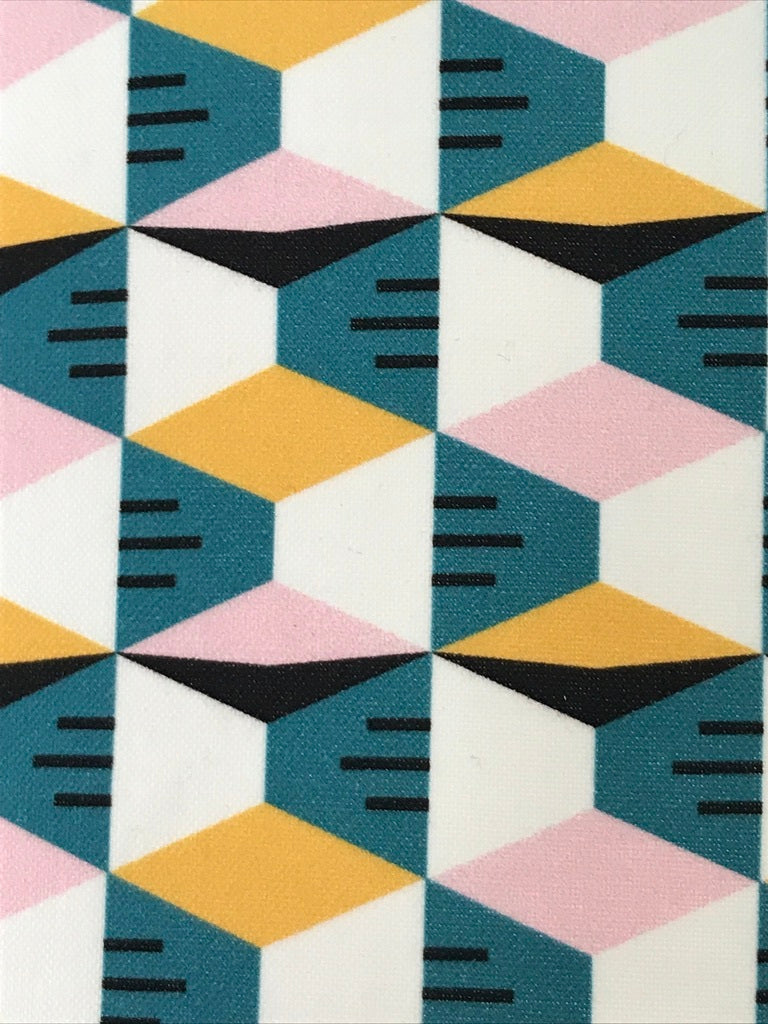 Close up of cotton fabric with a mustard, pink, white and blue geometric pattern.