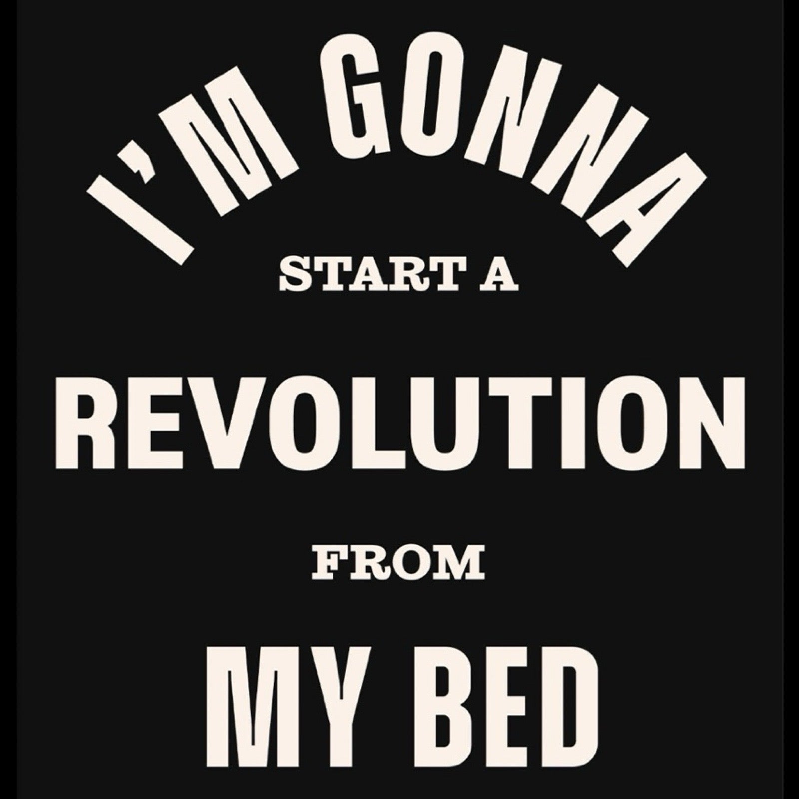 Print of the lyric 'I'm gonna start a revolution from my bed' from the song Don't Look Back in Anger by Oasis. The lyrics are written in white against a black background.