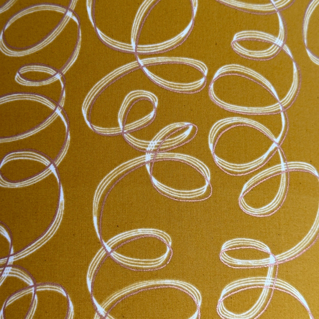 Mustard cotton fabric with white and gold ribbons.