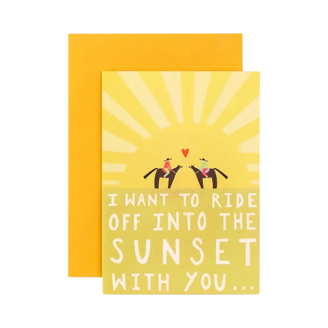 Love card with two people on horseback in the centre of a giant sun and the text ‘I want to ride off into the sunset with you’. 