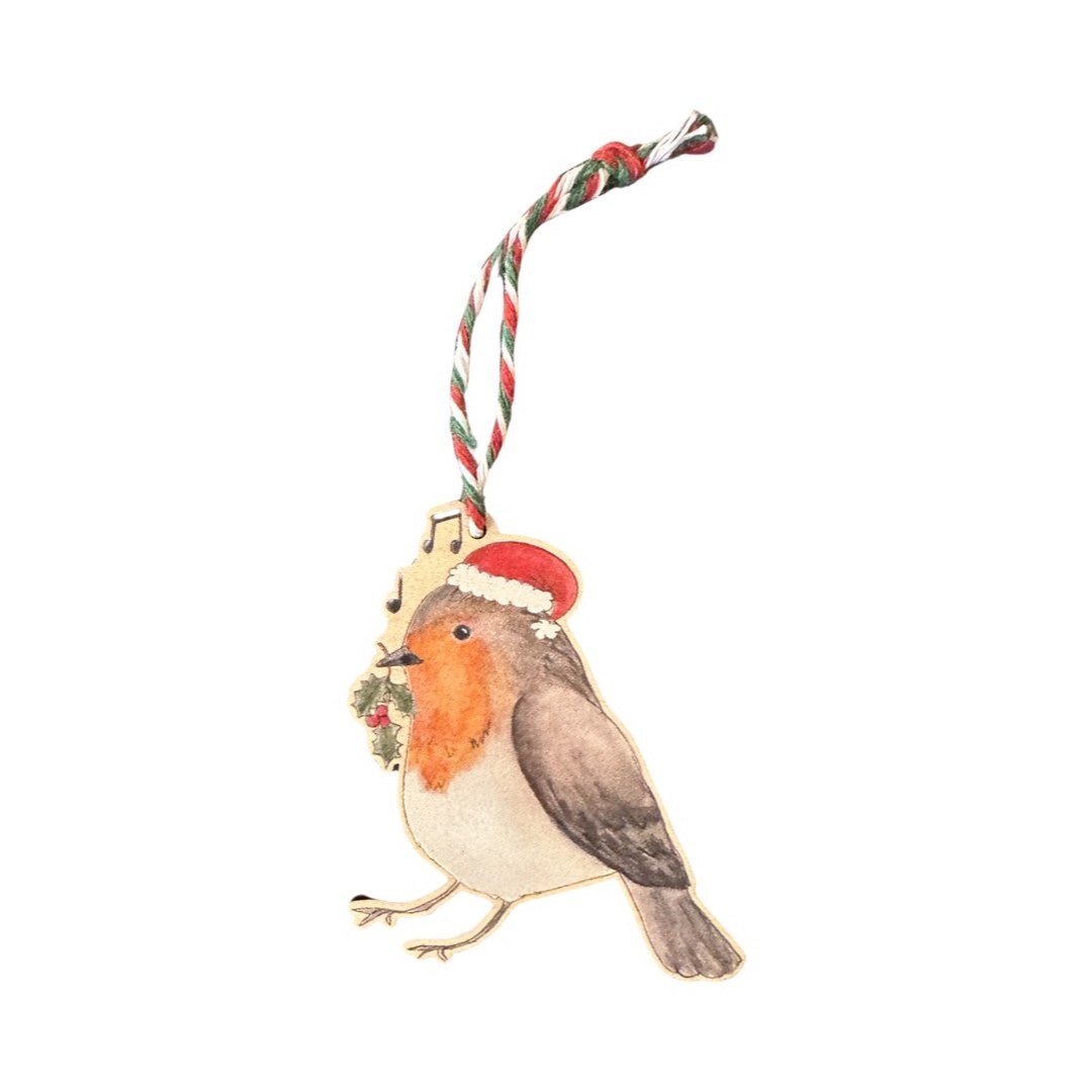 Christmas decoration of a robin wearing a Santa hat and holding a stem of holly in its beak