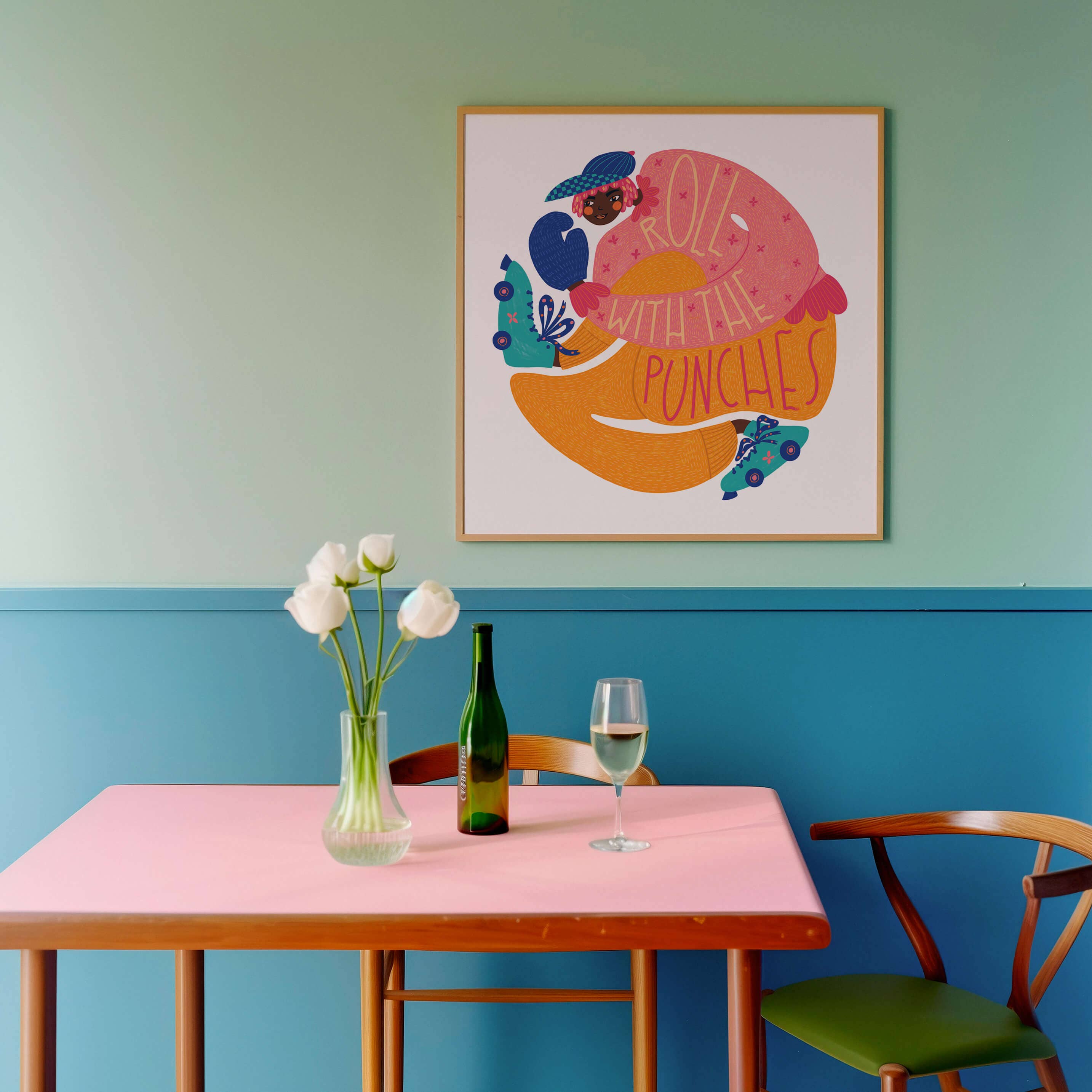 Dining area with a pink table, green bottle, glass, and vase against a blue and green wall with a colourful art print.