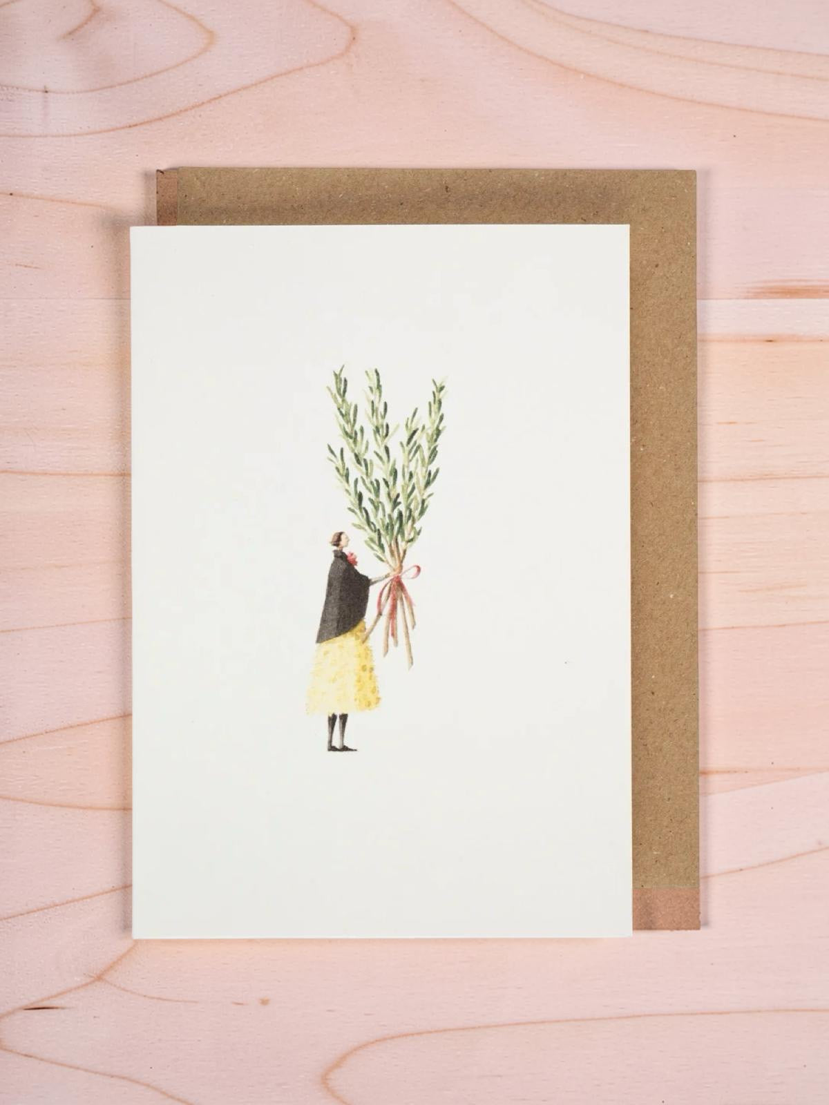 Framed artwork of a person holding a plant on a wooden surface.