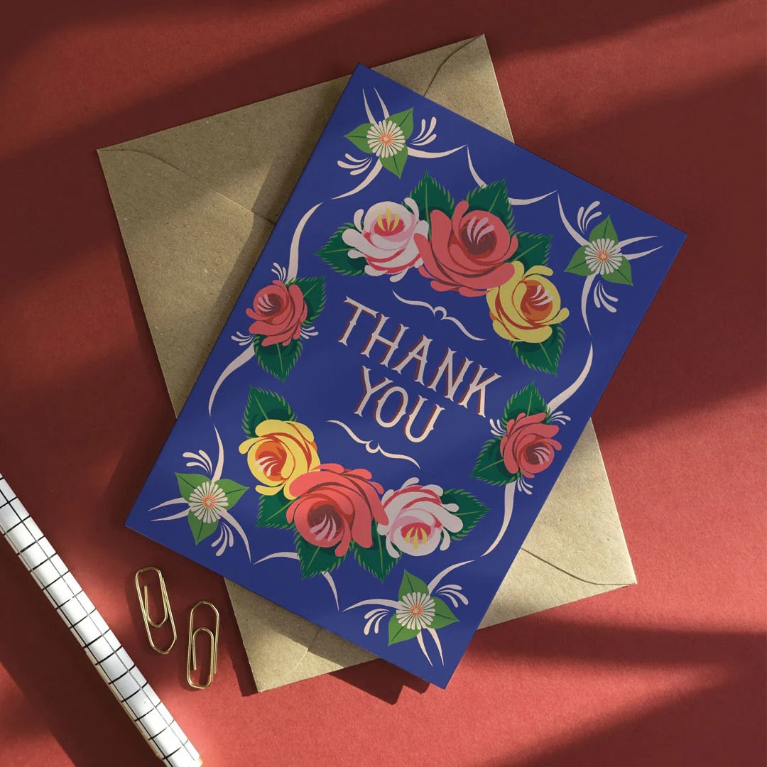 Floral 'Thank You' card with an envelope on a red background.