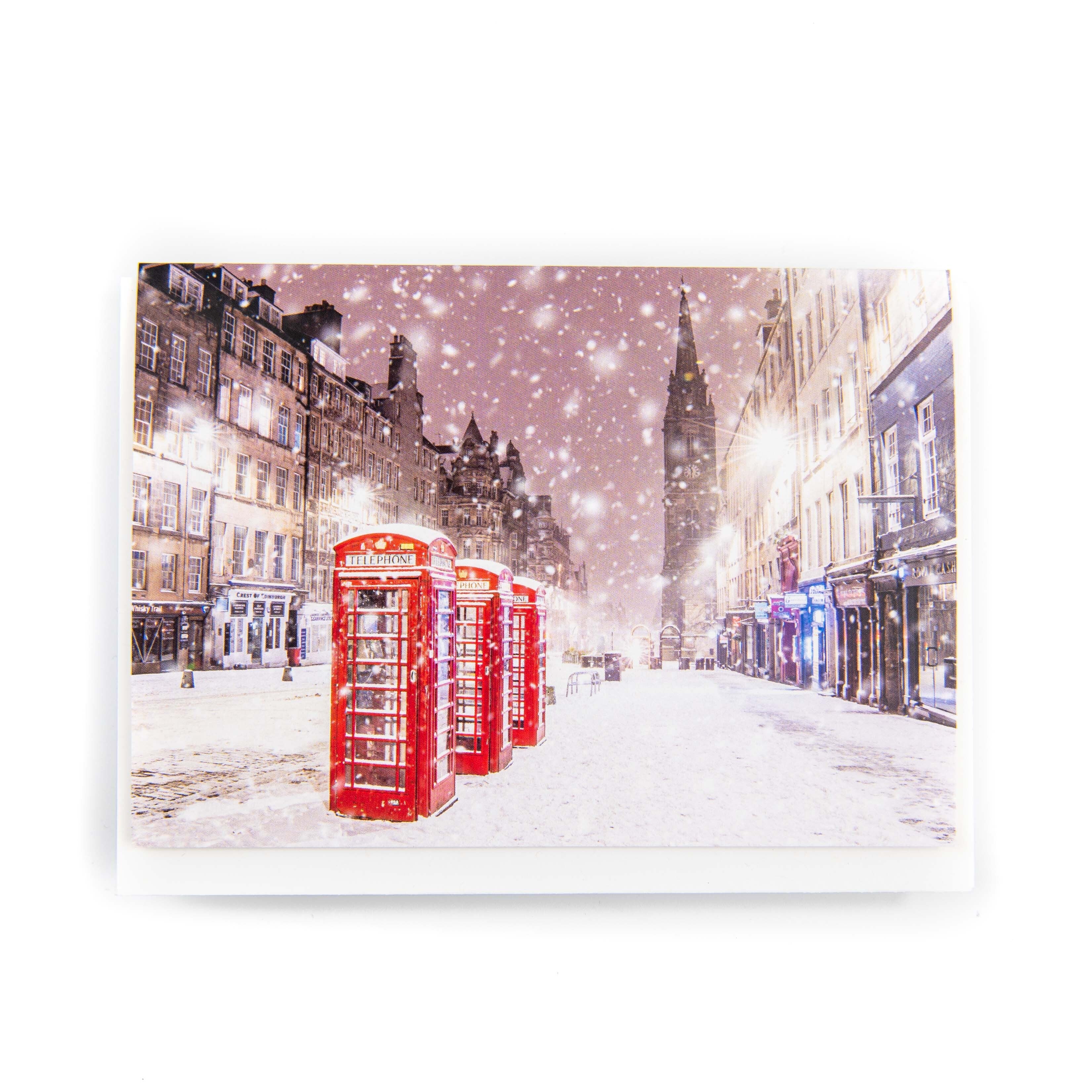 A Christmas card featuring the Royal Mile in Edinburgh with snow on the ground and red phone boxes along the street.