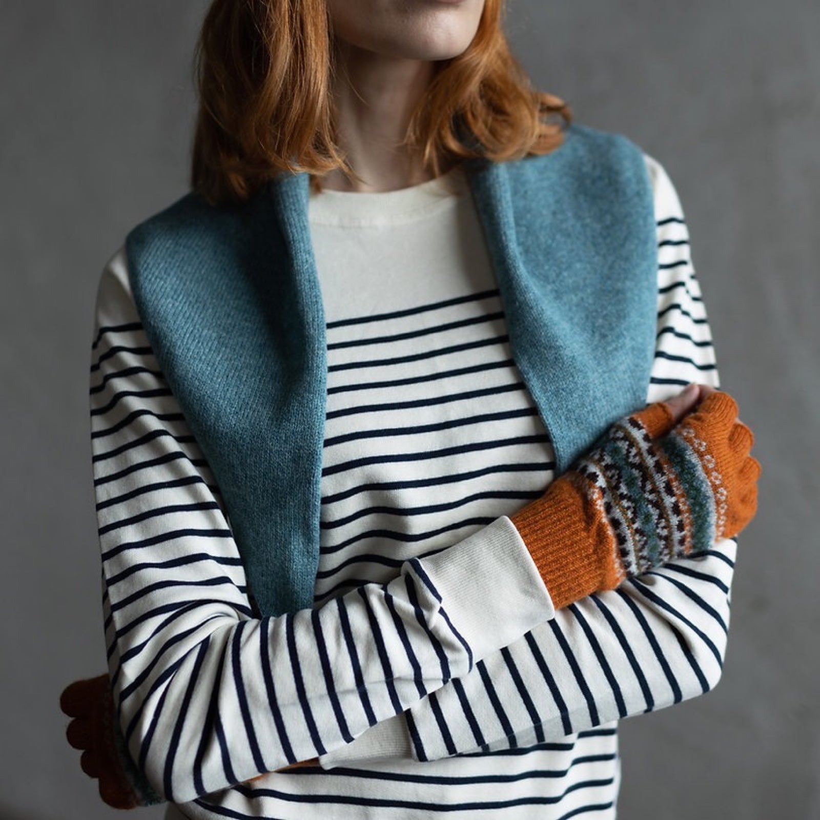 Ladies' orange fingerless gloves with a contemporary pattern in blue, navy and white are made from 100% lambswool.