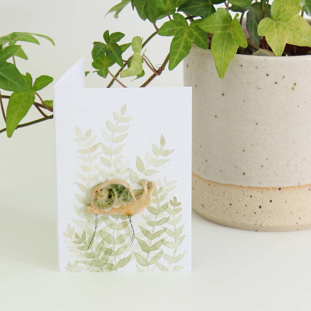 Snail plant hugger, handmade using British clay and recycled glass, on backing card.