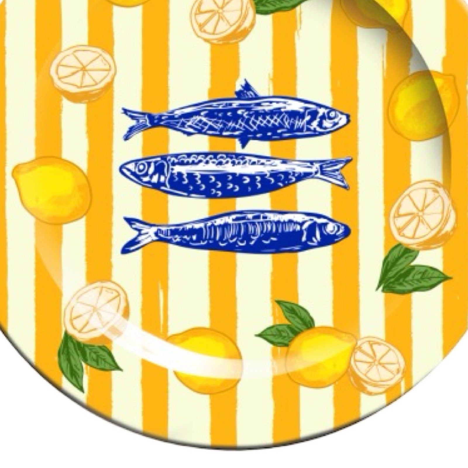 Decorative plate with yellow and white striped pattern, blue fish, and lemons on a white background.