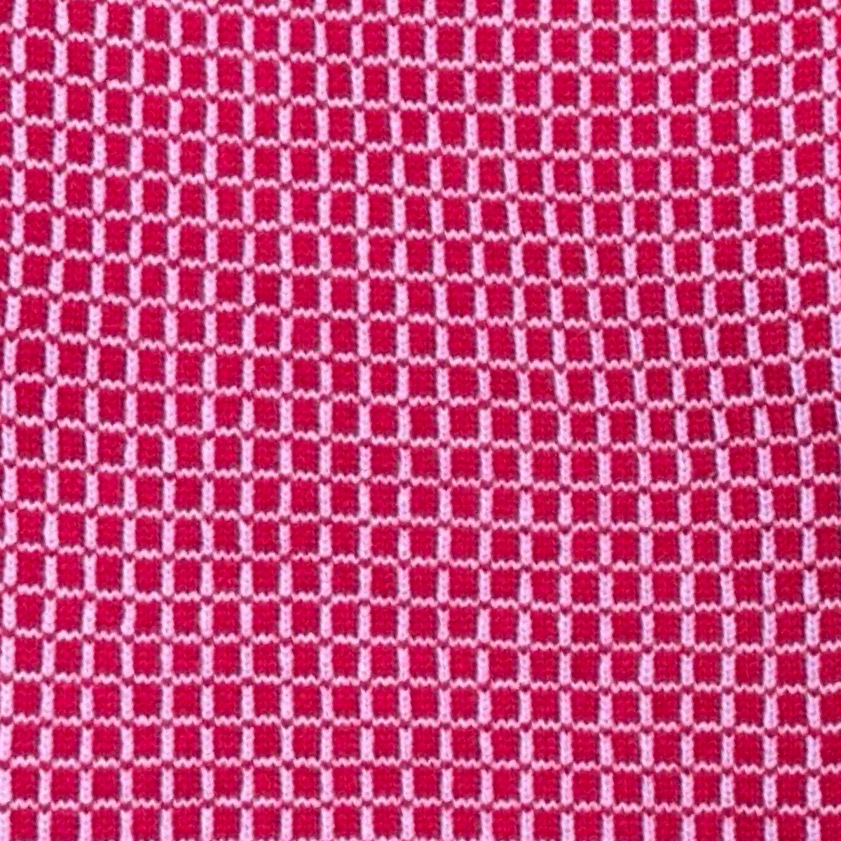 A close-up of a woven fabric texture featuring a repeating red and light pink geometric checkered pattern.