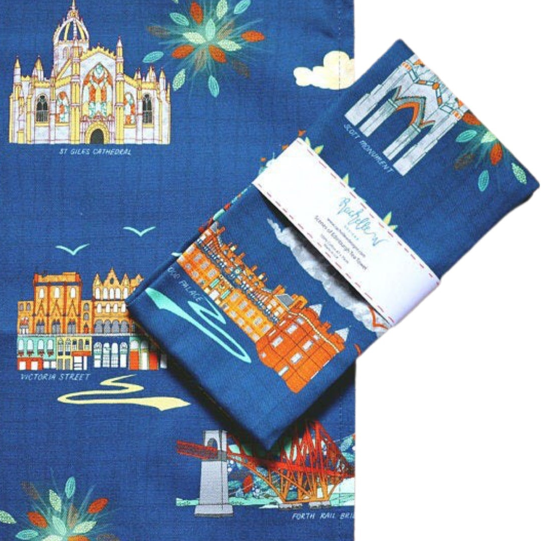 Folded tea towel featuring iconic Edinburgh landmarks Edinburgh Castle, St. Giles Cathedral, the Scott Monument and more on a blue background.
