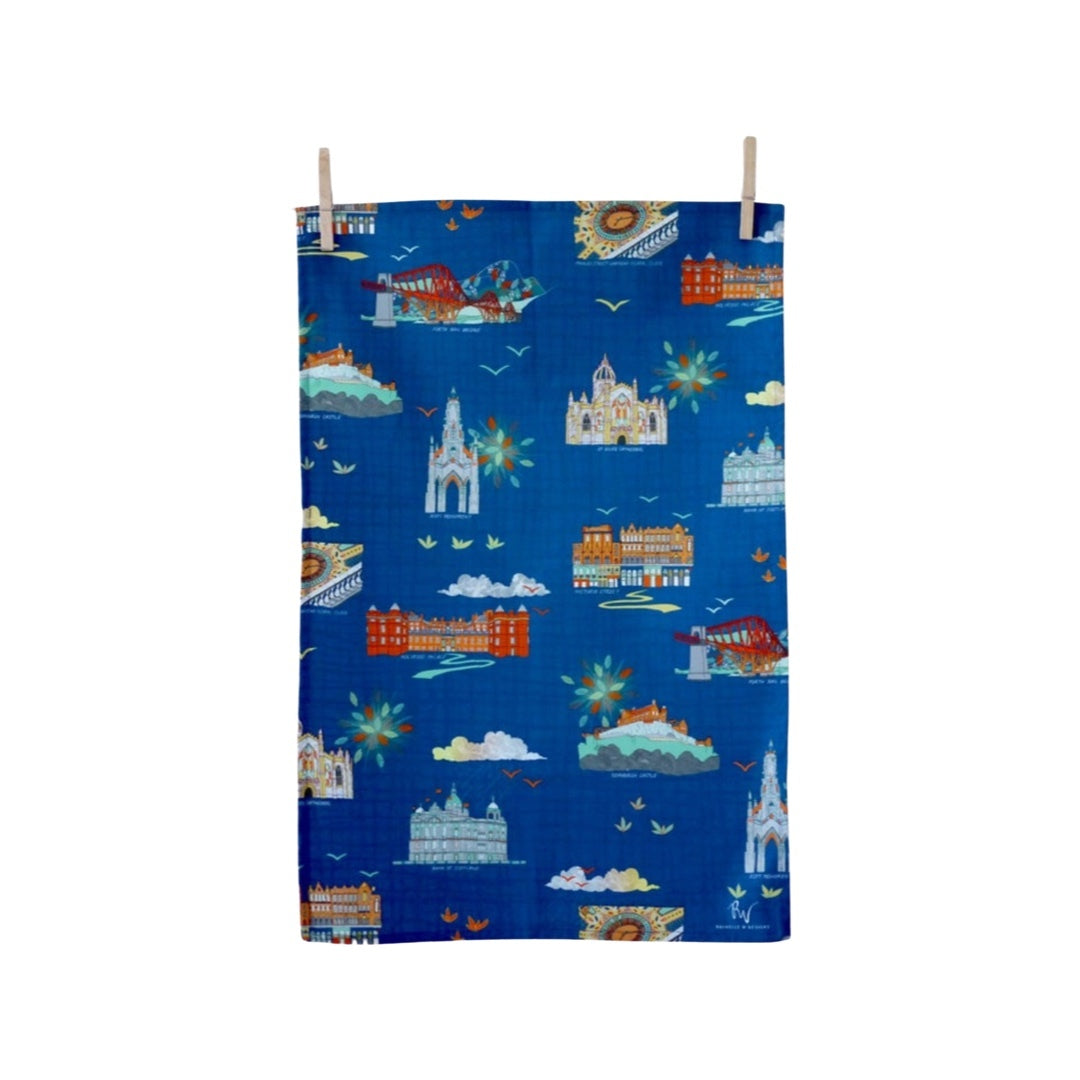 Tea towel featuring iconic Edinburgh landmarks Edinburgh Castle, St. Giles Cathedral, the Scott Monument and more on a blue background.