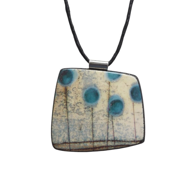 This pendent necklace is made from black porcelain casting slip layered with a white decorating slip and a ceramic decal.