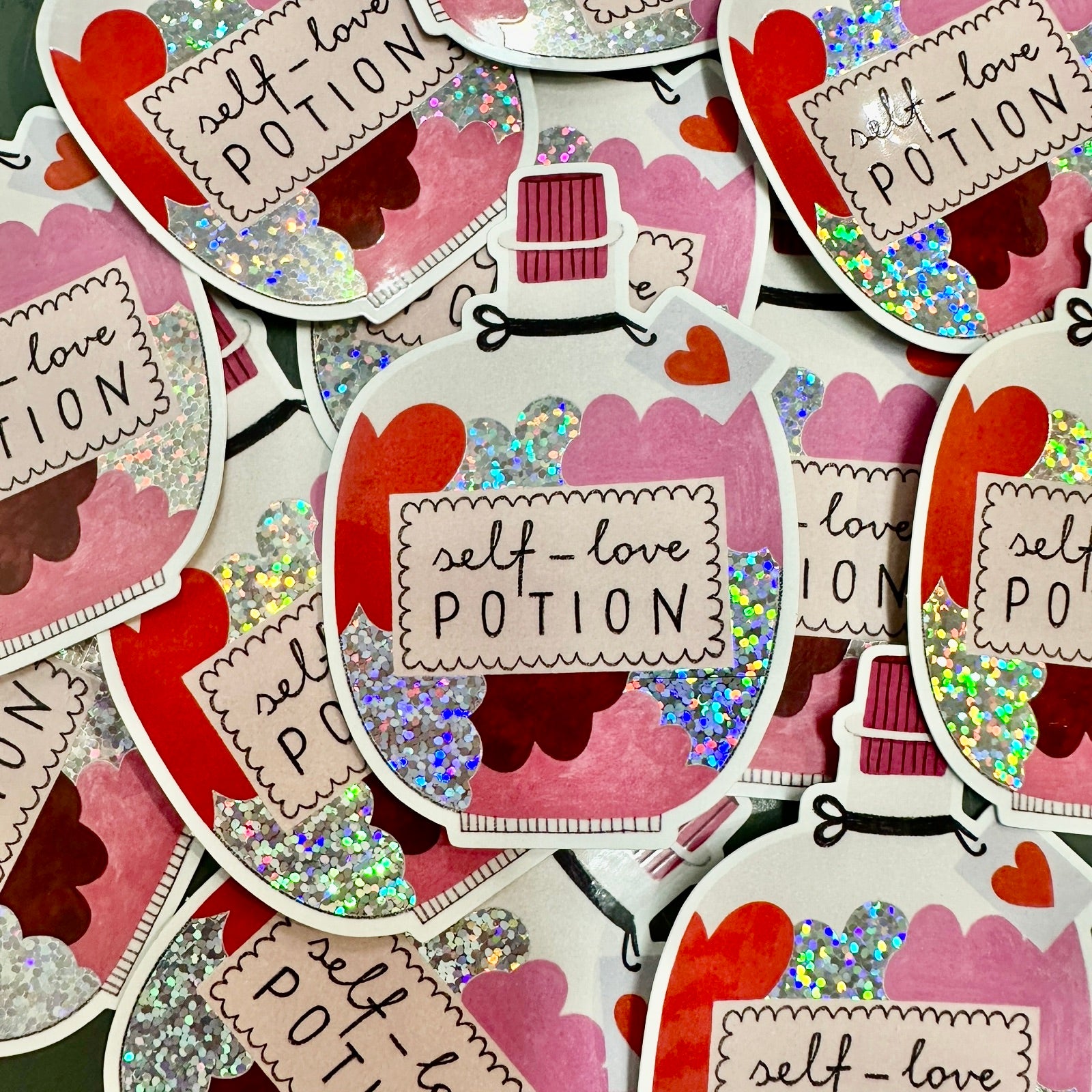 A vinyl sticker of a jar filled with a pink, silver glitter and red self-love potion.