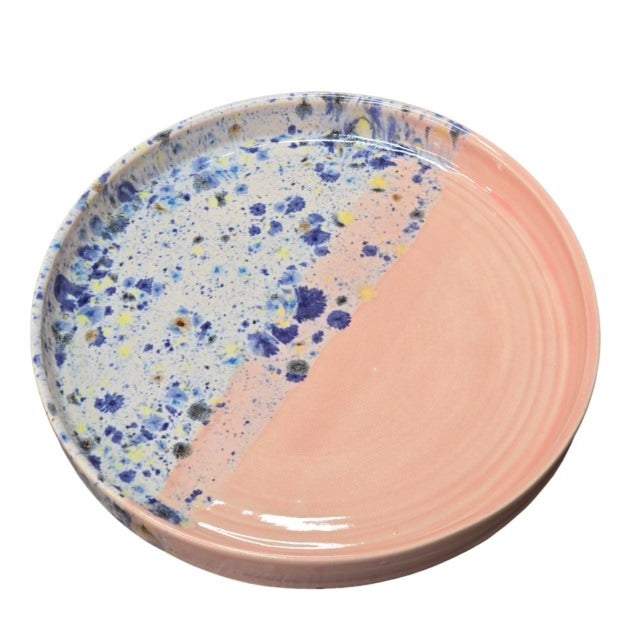 Handmade ceramic trays with half in a shoreline design and half block colour, in pink and blue.