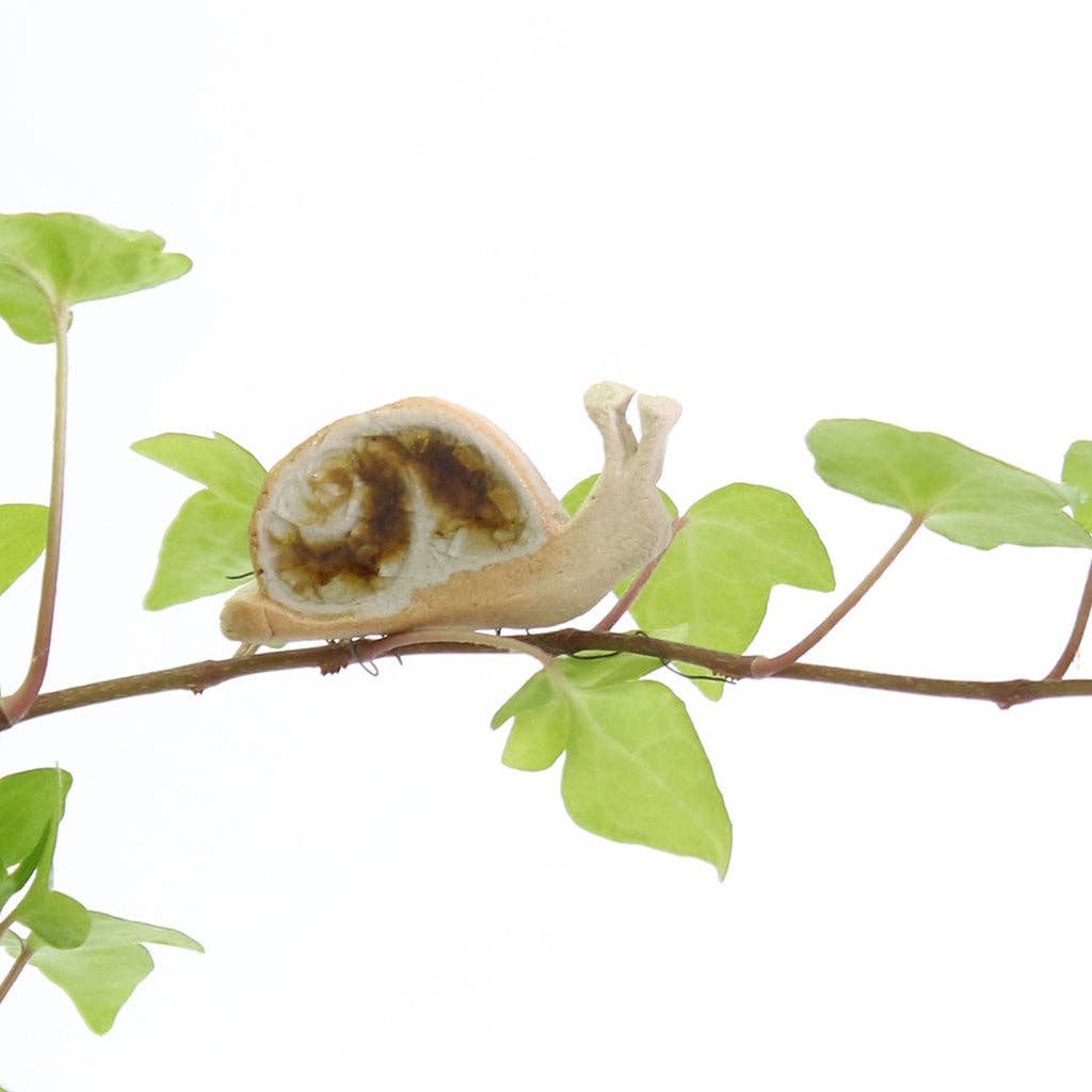 A snail shaped ceramic plant hugger decoration decorated with brown and white recycled glass