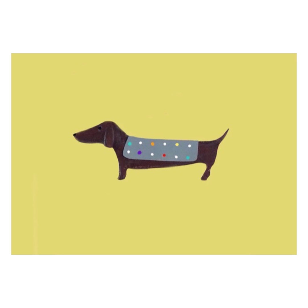 A3 poster print of a sausage dog wearing a grey coat with colourful polka dots all against a lemon background.