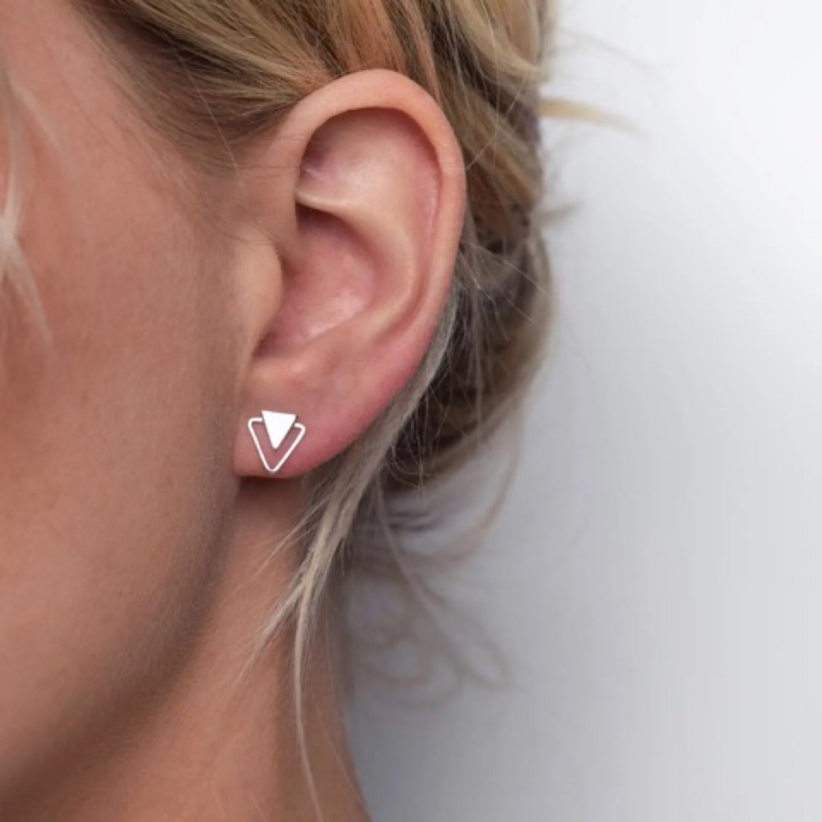 Handmade silver stud earrings featuring a double triangle design.
