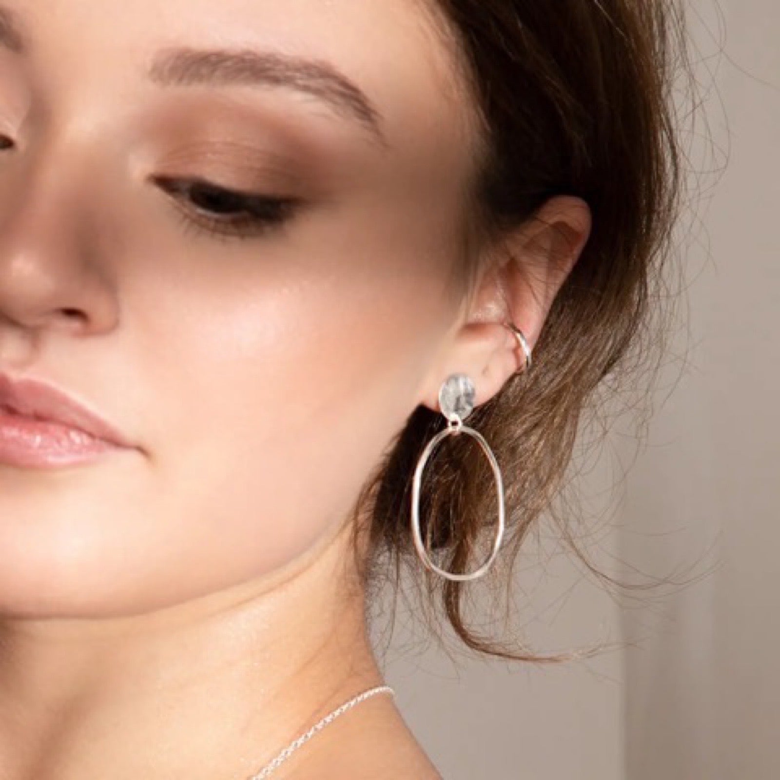Handmade silver hoop earrings with a stud fixing.
