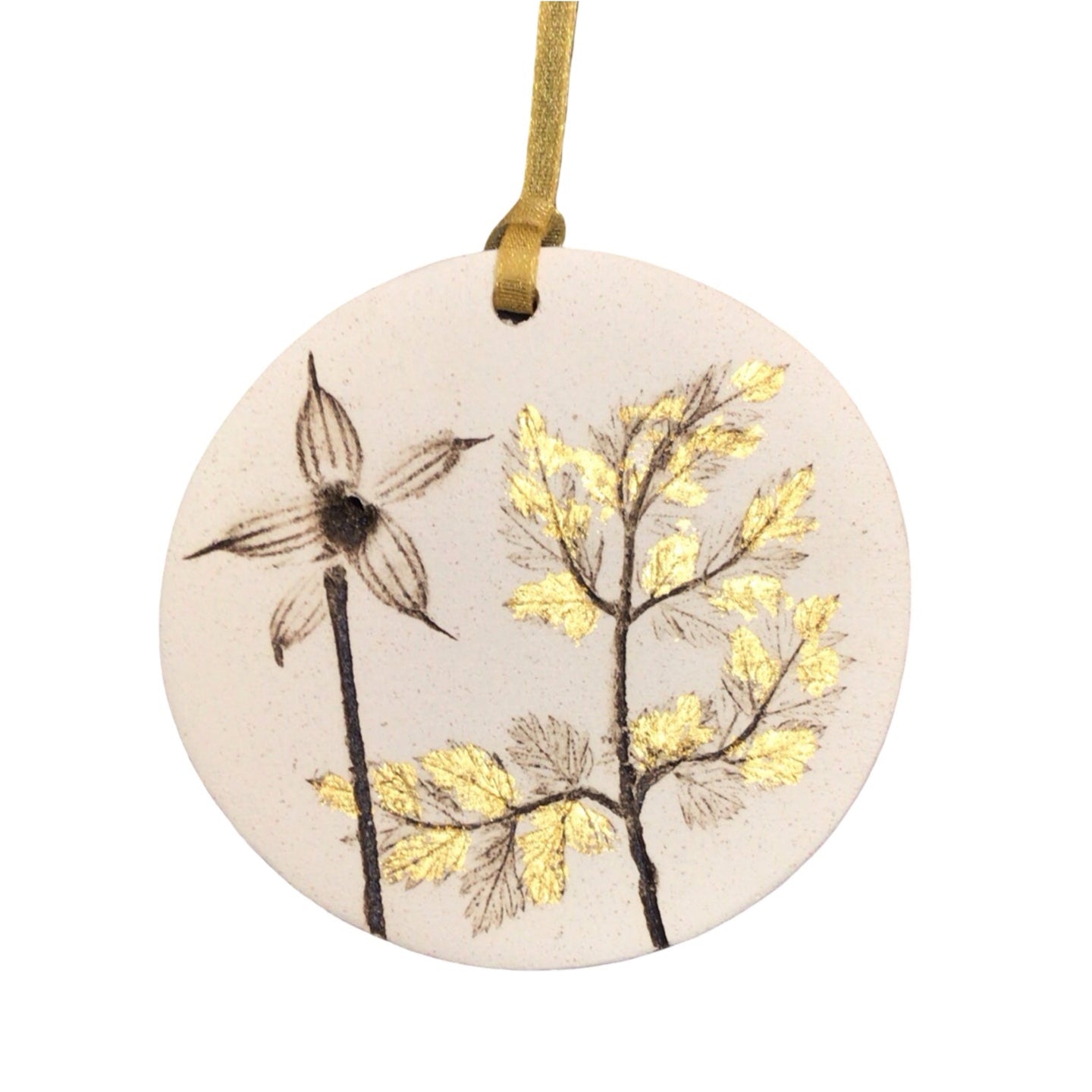 Round ceramic ornament with floral design and gold accents on a white background